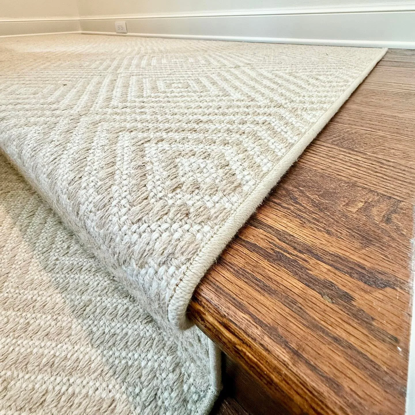 Transform your staircase from a functional pathway into a stunning design focal point. We crafted this custom broadloom runner to flow seamlessly from the landing down the stairs, bringing warmth and style to this home. Our process includes precise t