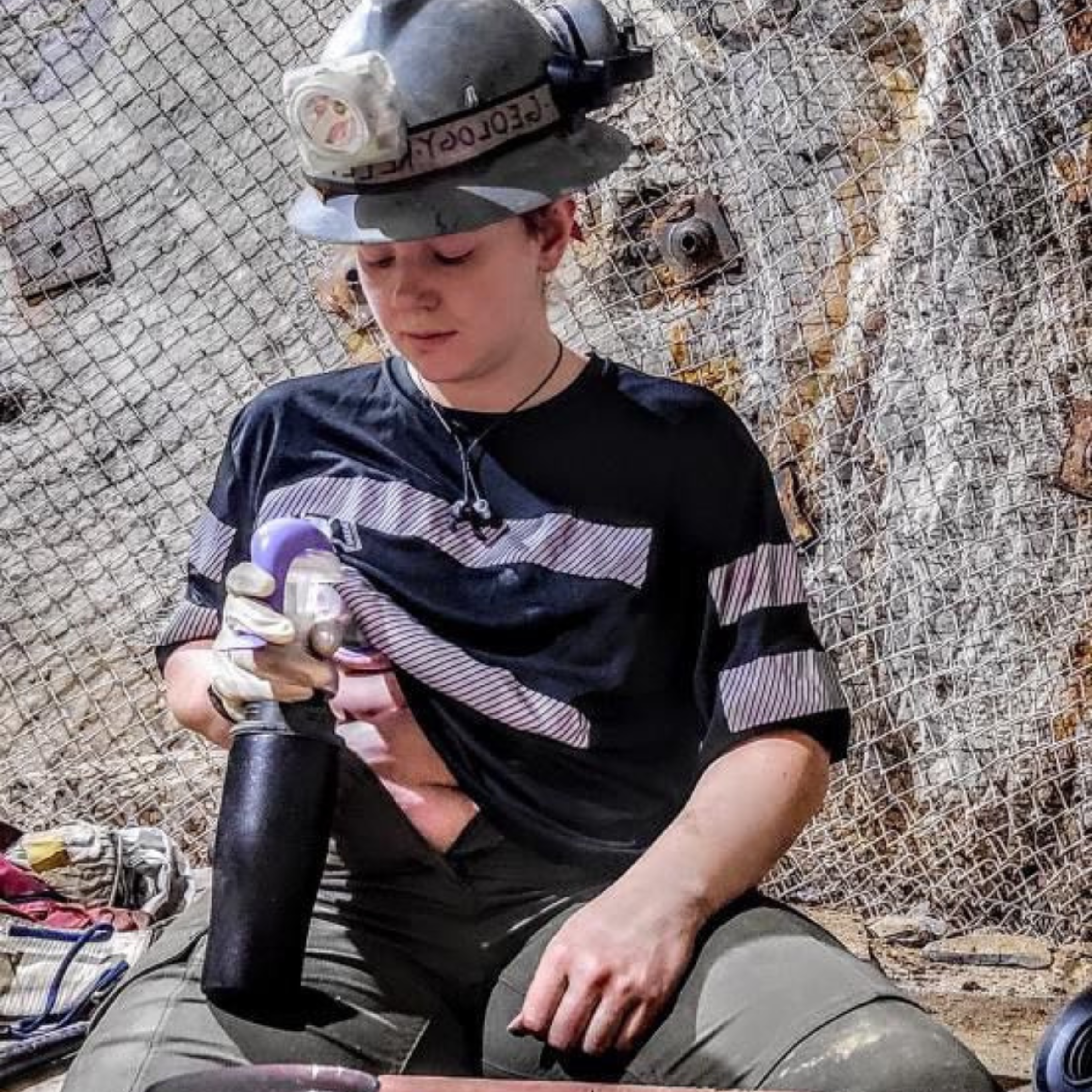 Mom in work clothes pumping breast milk on a job site and storing it in a black Ceres Chill breastmilk chiller
