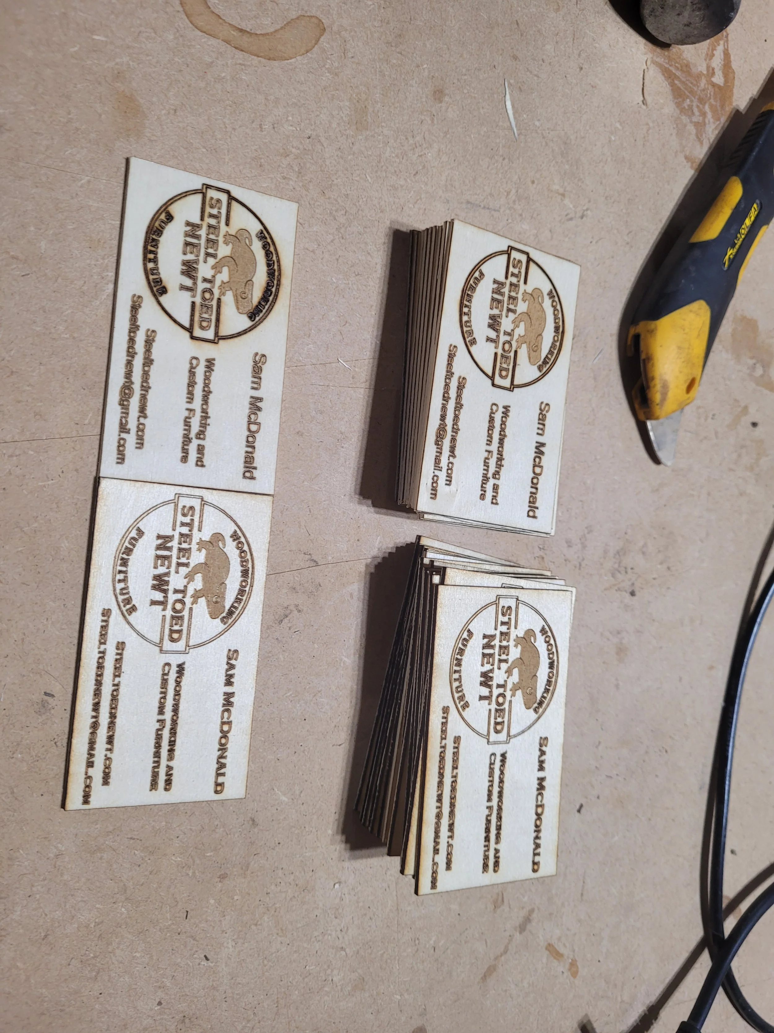 Stacks of finished wooden business cards on workbench