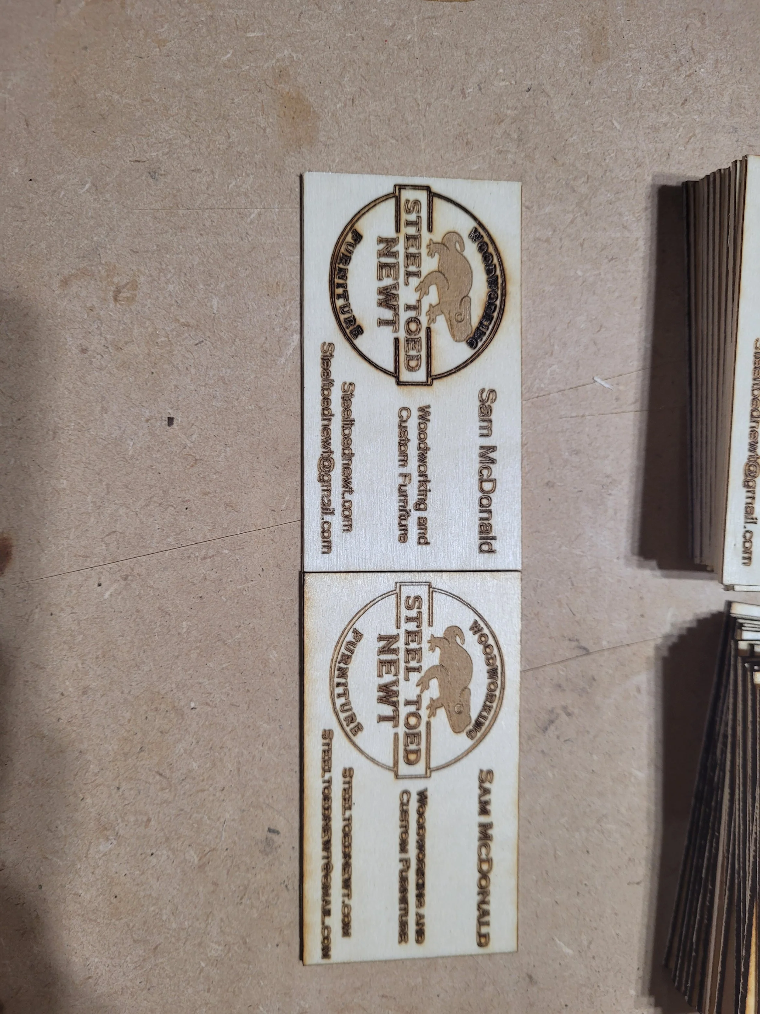 Close-up of Steel Toed Newt laser-engraved wooden business cards