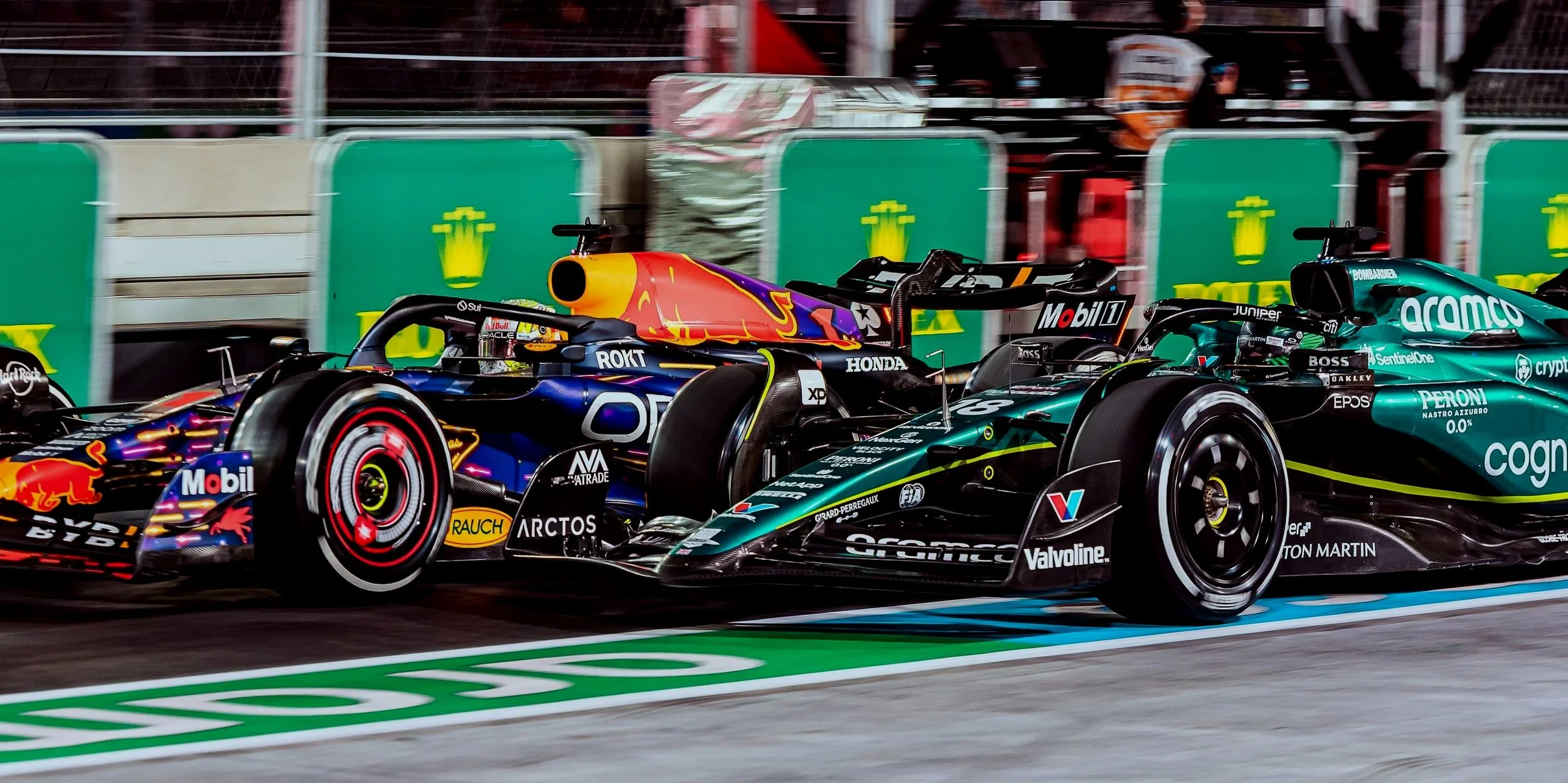Two Formula 1 race cars on a track, with a Red Bull Racing car on the left and a Mercedes-AMG Petronas car on the right, during a race.