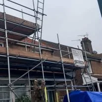 Scaffolding erected around a residential property to provide safe access for roof repairs, exterior renovation and general building maintenance. West Sussex Coastal Scaffolding Ltd.