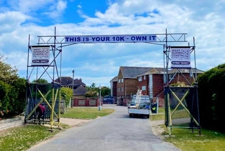Freestanding scaffold access structure spanning a roadway, erected by West Sussex Coastal Scaffolding Ltd for safe access during works.