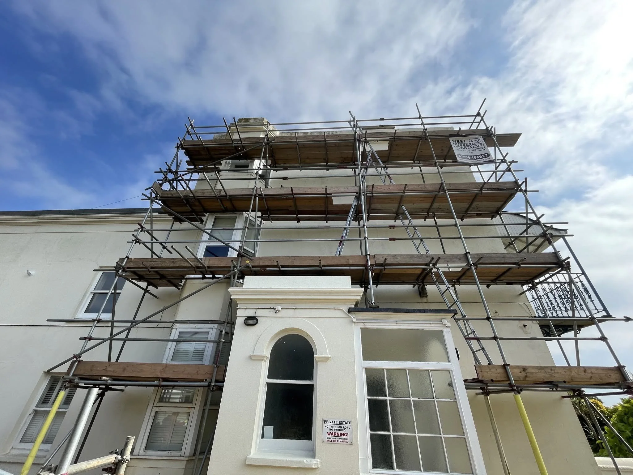 Multi-level scaffolding erected around a large property to provide safe access for exterior renovation, roofing and maintenance works. West Sussex Coastal Scaffolding Ltd.