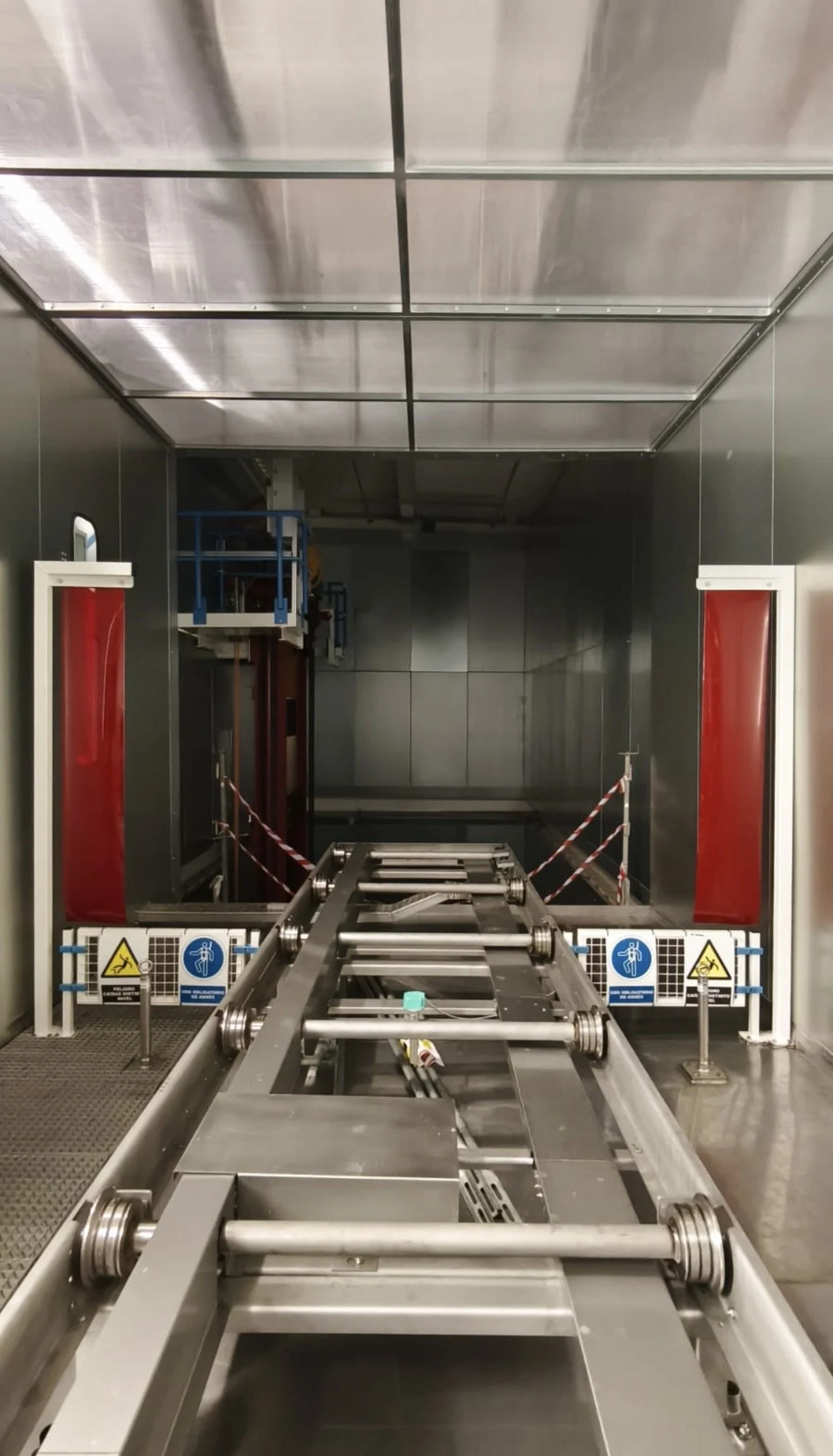 Estructura metálica grande en un almacén industrial, sobre un camión, con techos altos y vigas de acero.