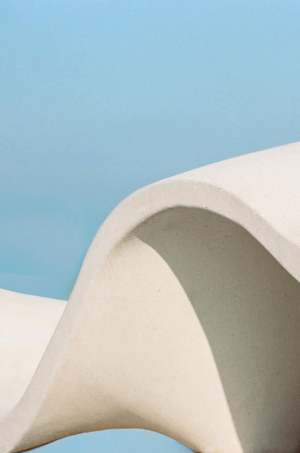 Une structure ondulée en stuc de forme organique avec un ciel bleu en fond