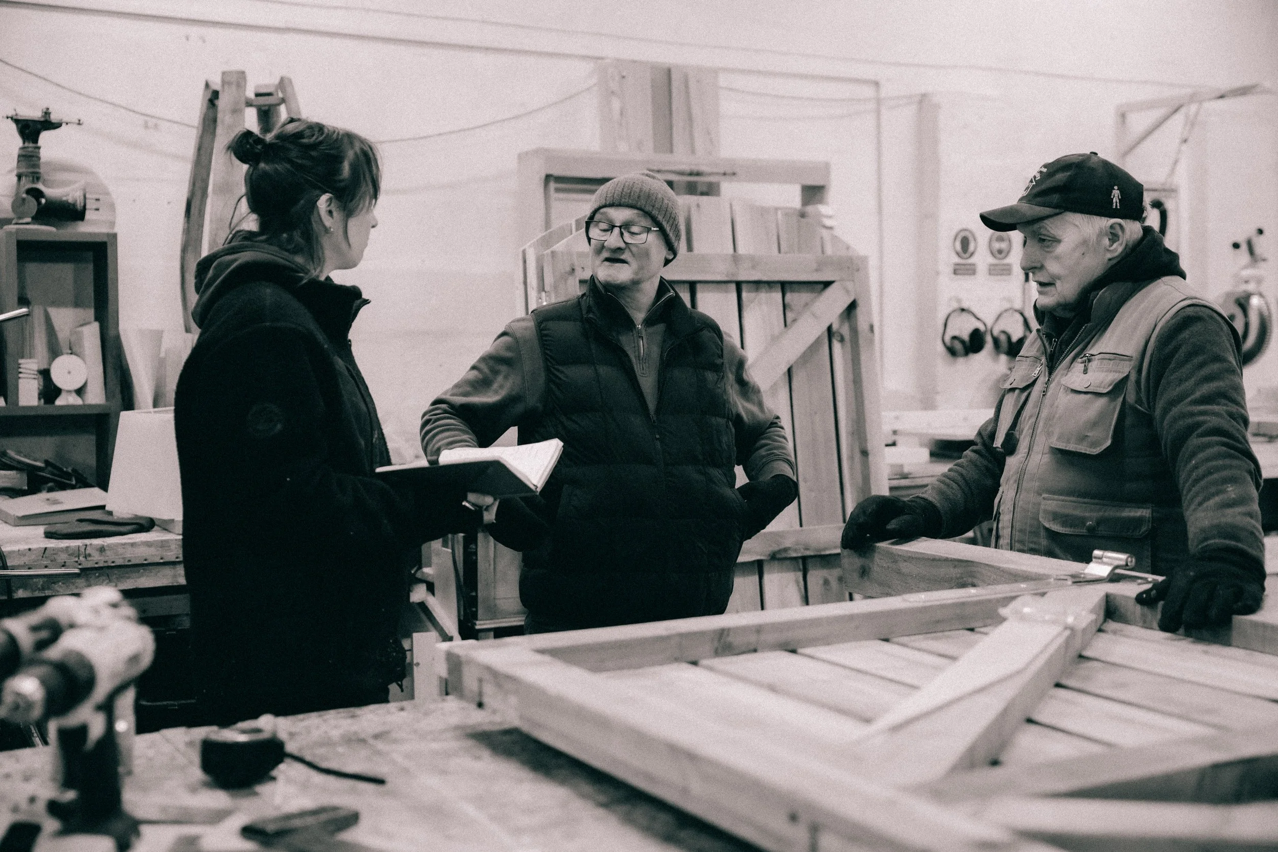 Owen Alistair and Freya from the Boomerang Team working on a wooden gates project at the workshop work bench