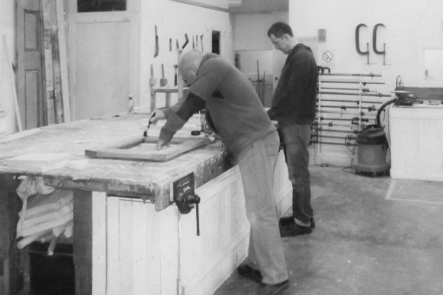 Historic photos of Boomerang Woodworking at it's conception. People working at a communal work bench at Boomerang Woodworking Glasgow
