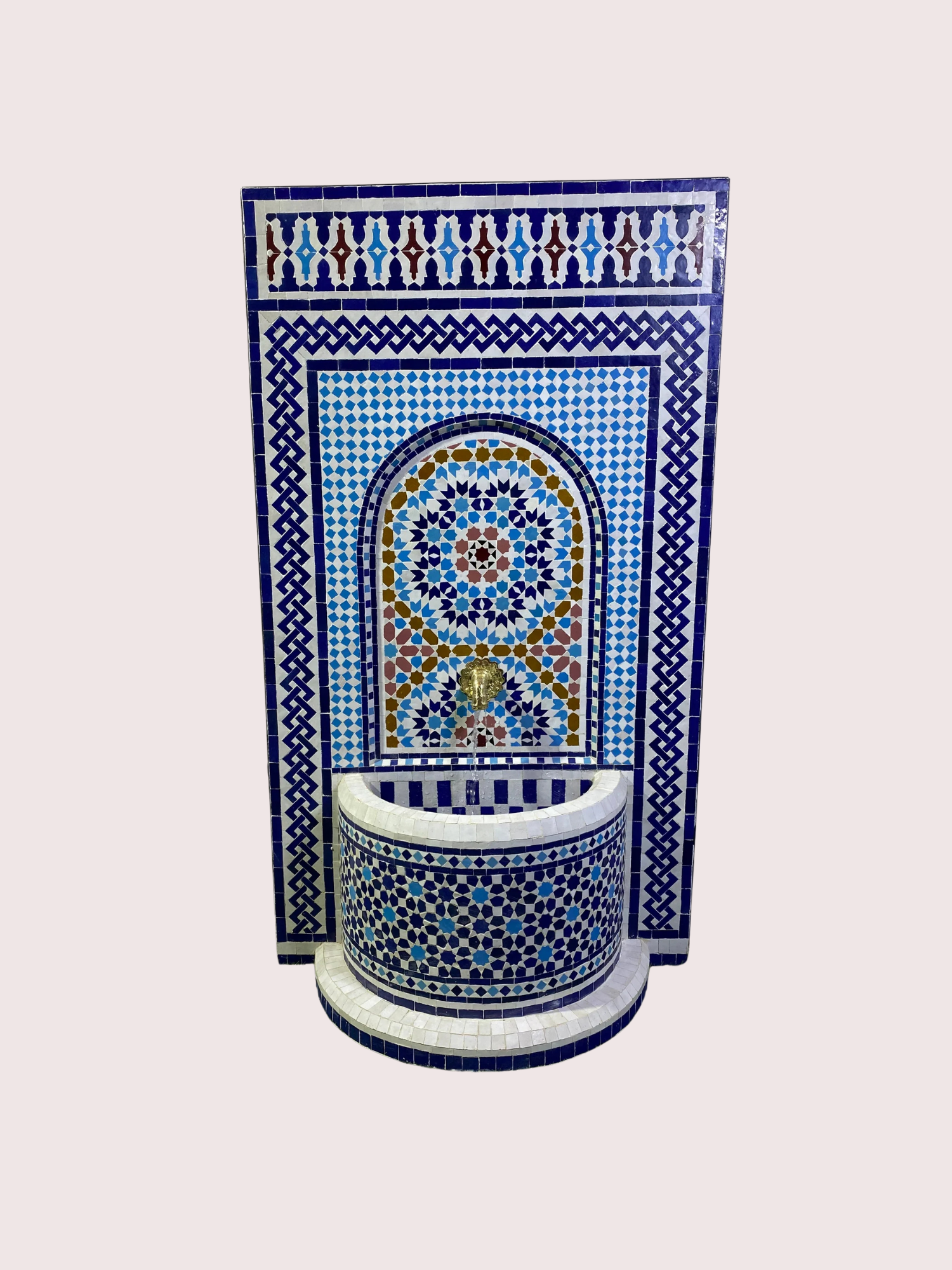 Decorative fountain with intricate blue, white, and gold mosaic tiles and a gold spout, set against a plain background.