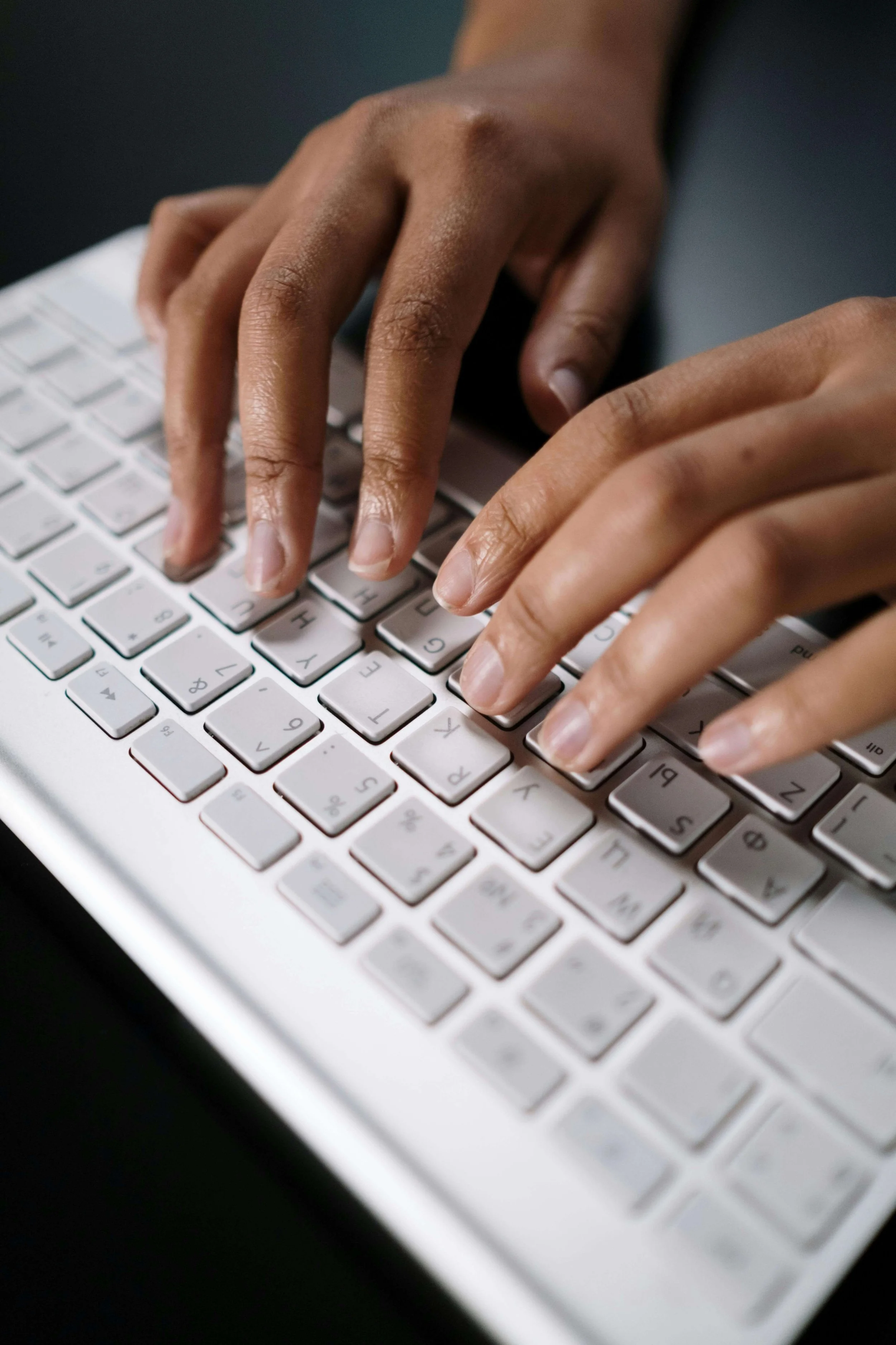 Hands working on a laptop, symbolizing improved communication clarity, organization, and professional expression through speech coaching.