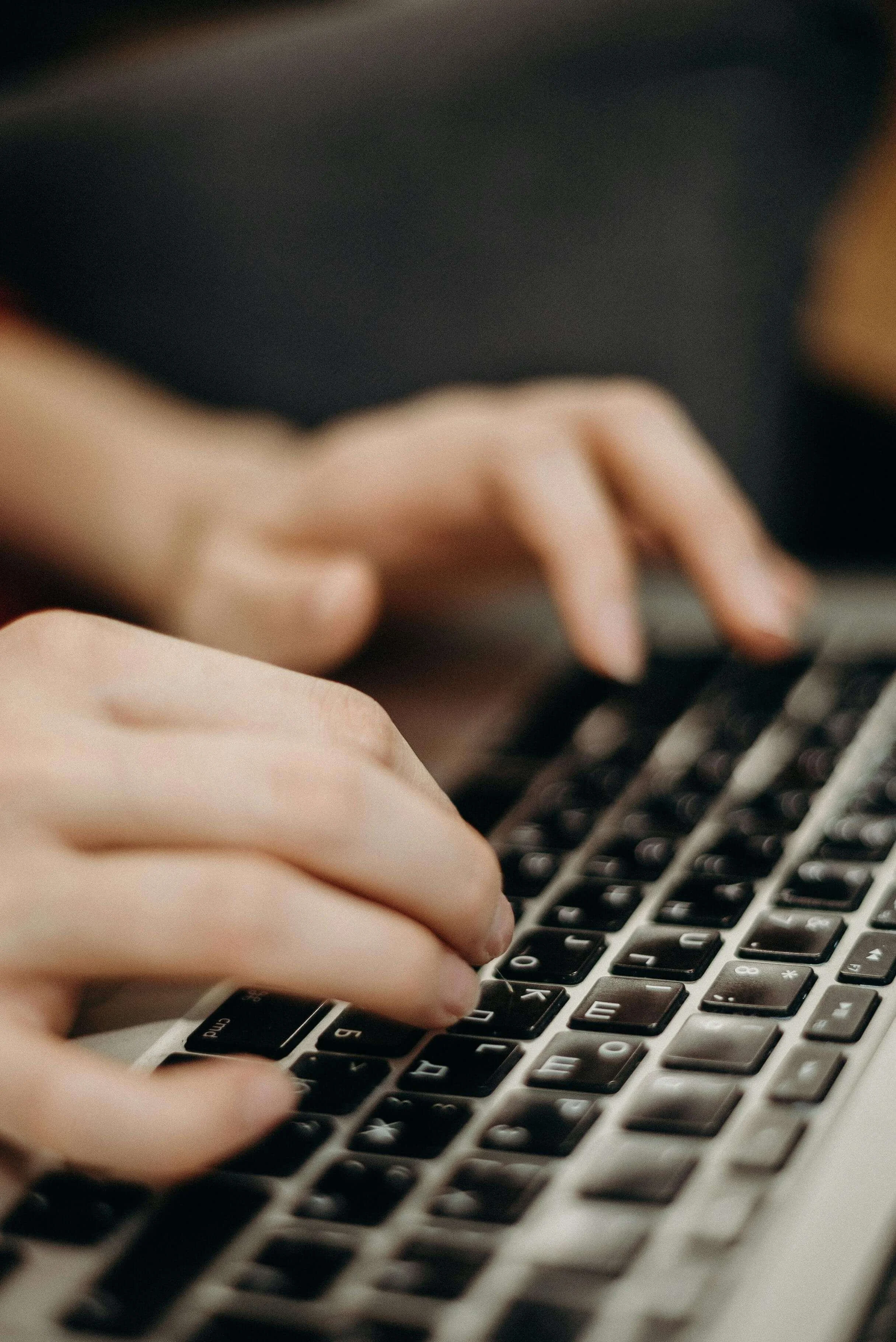 Hands working on a laptop, symbolizing improved communication clarity, organization, and professional expression through speech coaching.