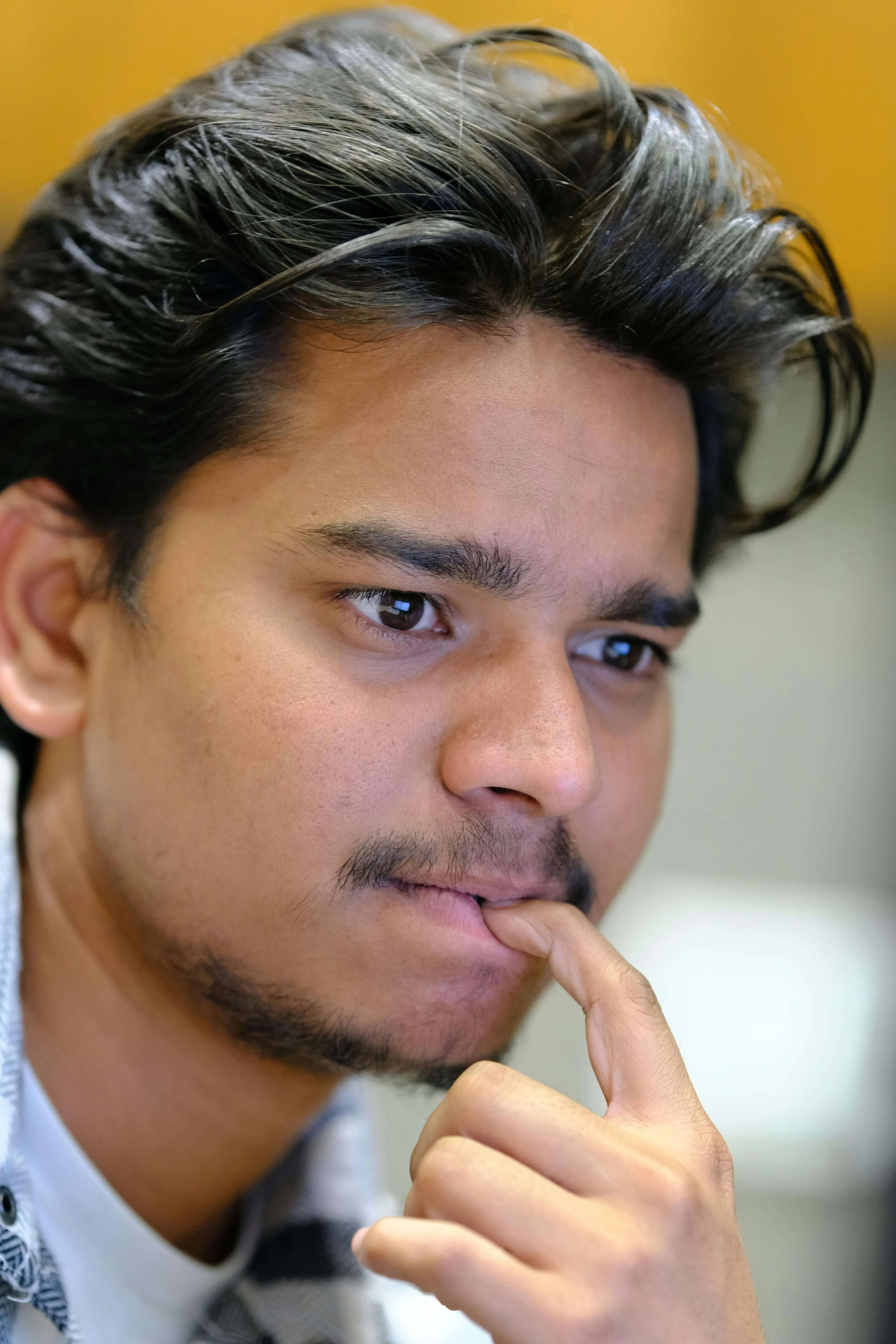 Close-up of a young man thinking deeply, representing communication coaching insights and self-awareness after reviewing communication quiz results.