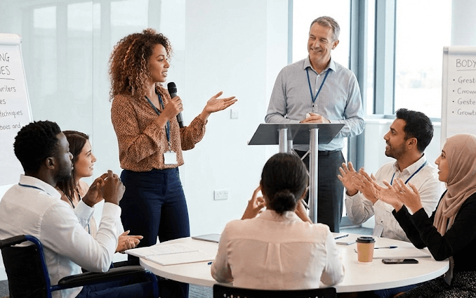 Professionals participating in an in-person communication workshop, practicing speaking skills and receiving real-time feedback.