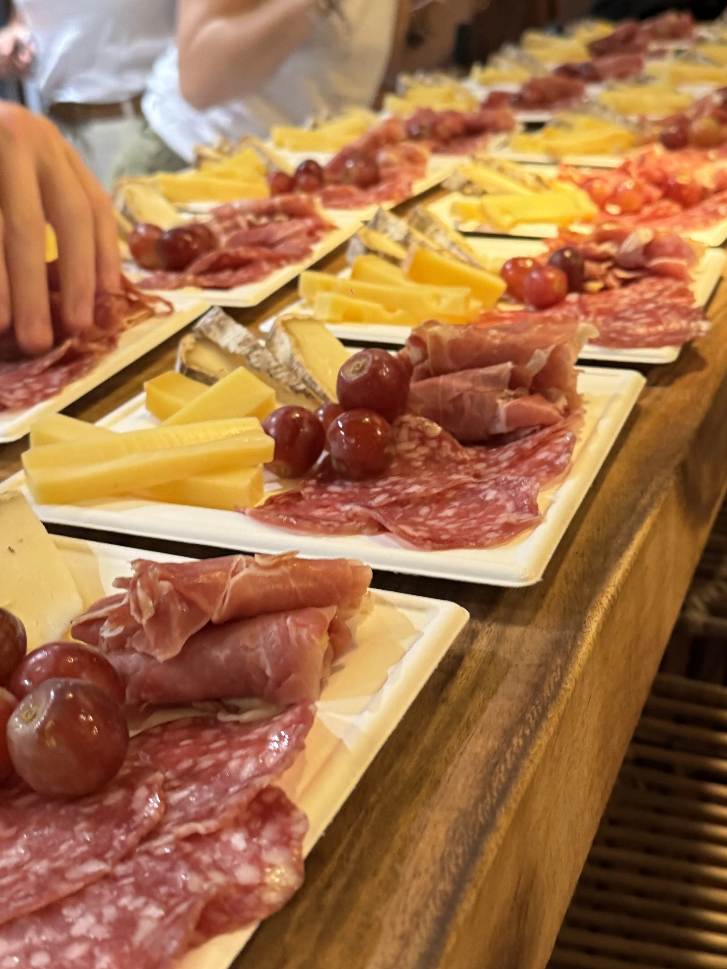 Plateau de charcuterie avec différents types de viandes, fromages, raisins et pain