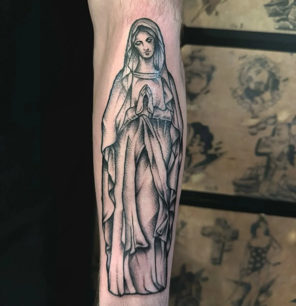 Tattoo of praying figure with hood on arm, black and gray style