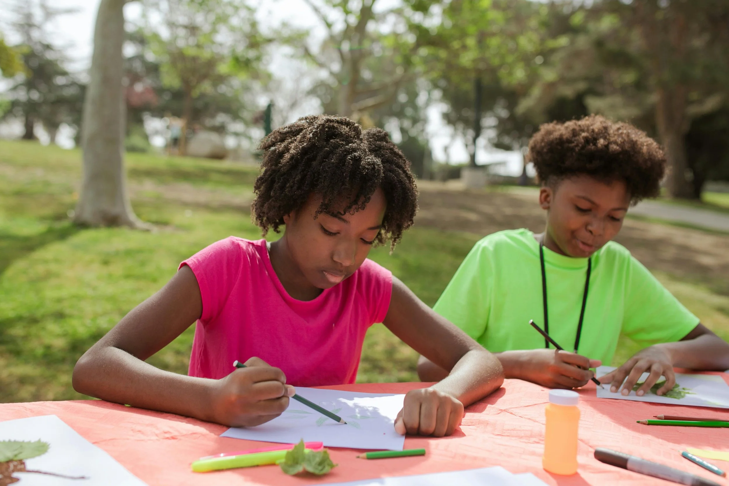 Two children do crafts outside