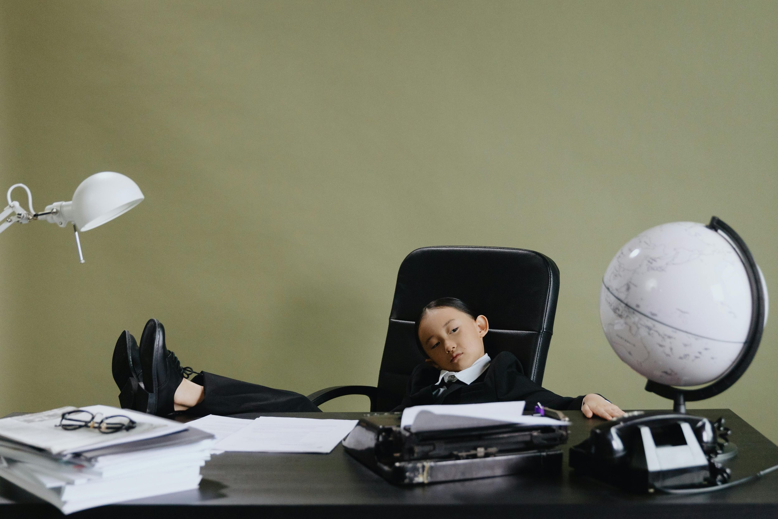 A child sat confidently in an executive office