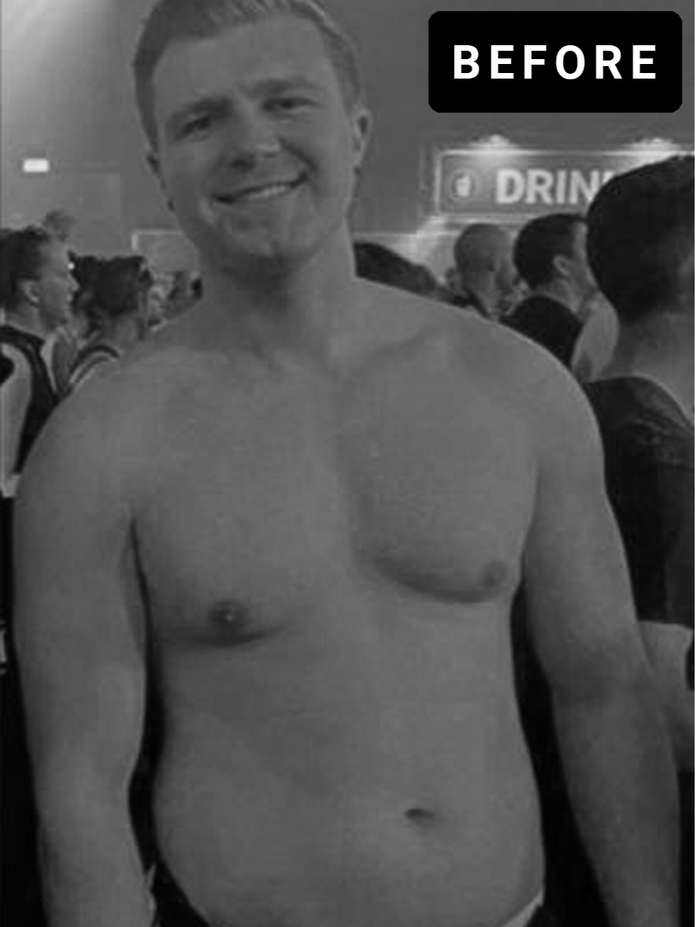 Een lachende man zonder shirt met een groep mensen op de achtergrond in een drukke omgeving, mogelijk een evenement of feest.