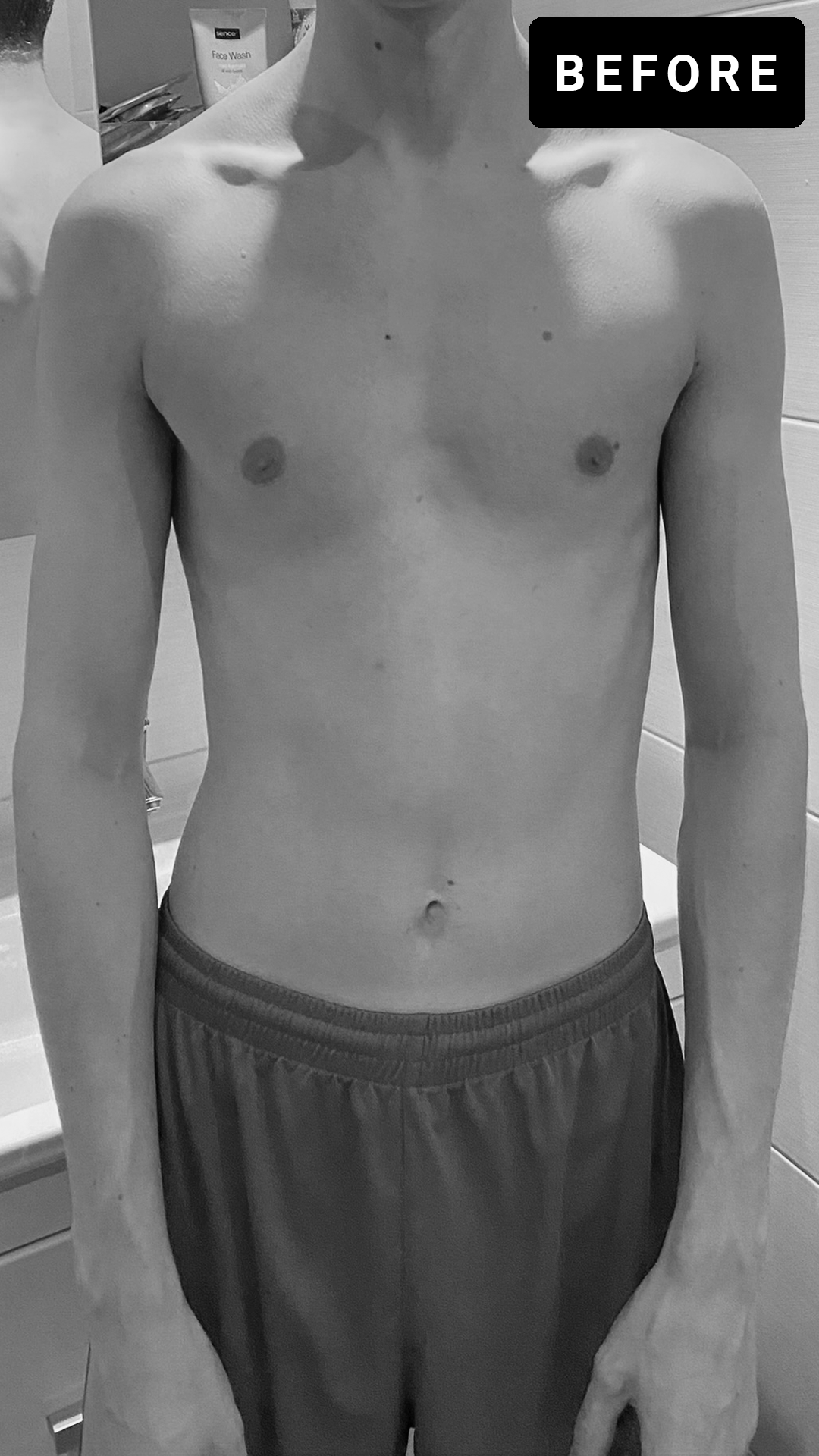 Bovenlichaam van een jonge man, blote borst, in zwart-wit, uiterlijk naar links gericht, met korte haar, broek met elastische band, achtergrond met toiletspullen.