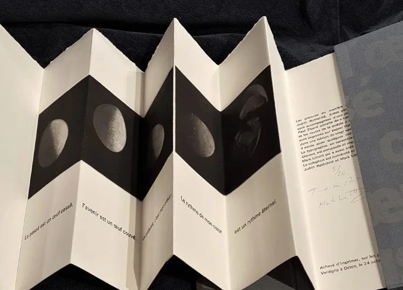 Open unfolded booklet with black and white images of an egg breaking and French text.