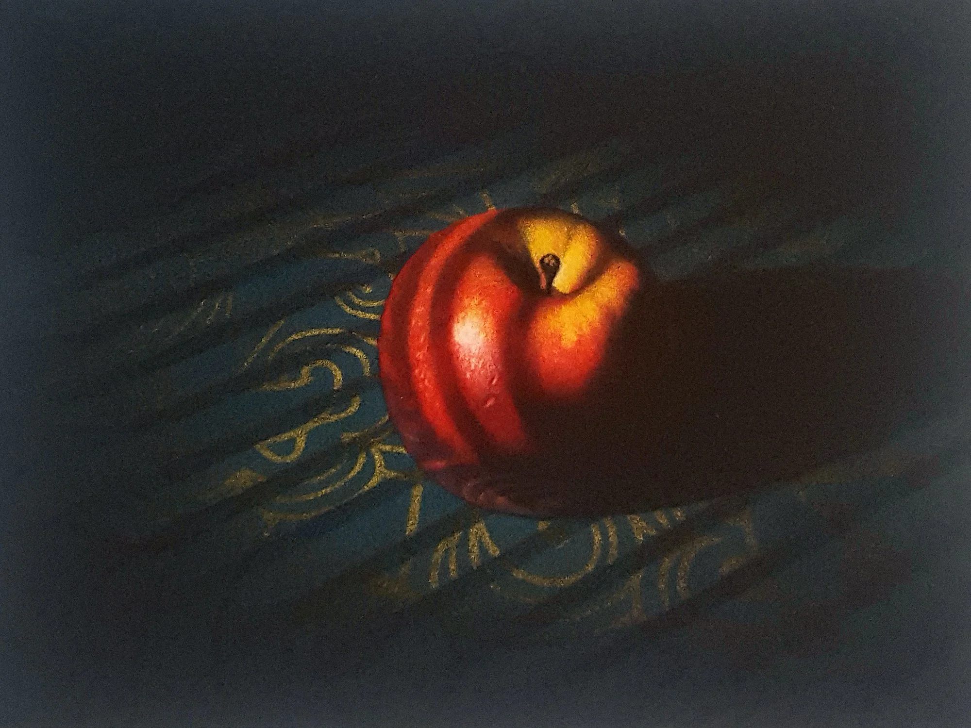 A still life mezzotint of a red apple, resting on a dark fabric with gold paisley patterns.