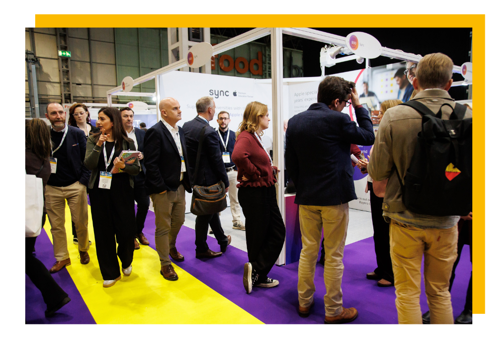 Visitors of the HE Transformation Expo interacting with each other around an exhibition stand