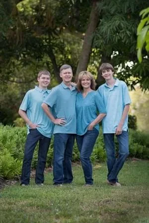 Diane Dultmeier with her husband and two teenage sons smiling together in a Stuart, Florida park