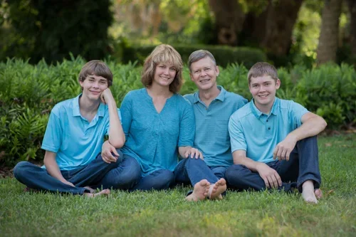 Diane Dultmeier and family sitting barefoot in the grass for a relaxed portrait