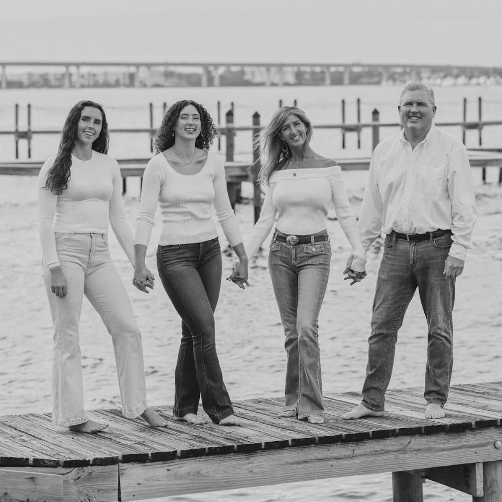 Diane Dultmeier professional black and white portrait of a family with two adult daughters on a waterfront dock in Stuart, Florida.