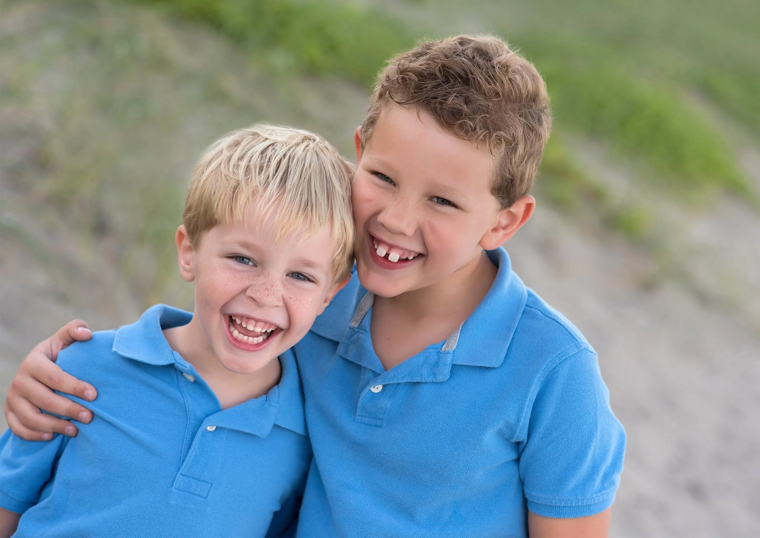 Close-up of two smiling brothers laughing during a family beach session at Stuart Beach with Dultmeier Photography