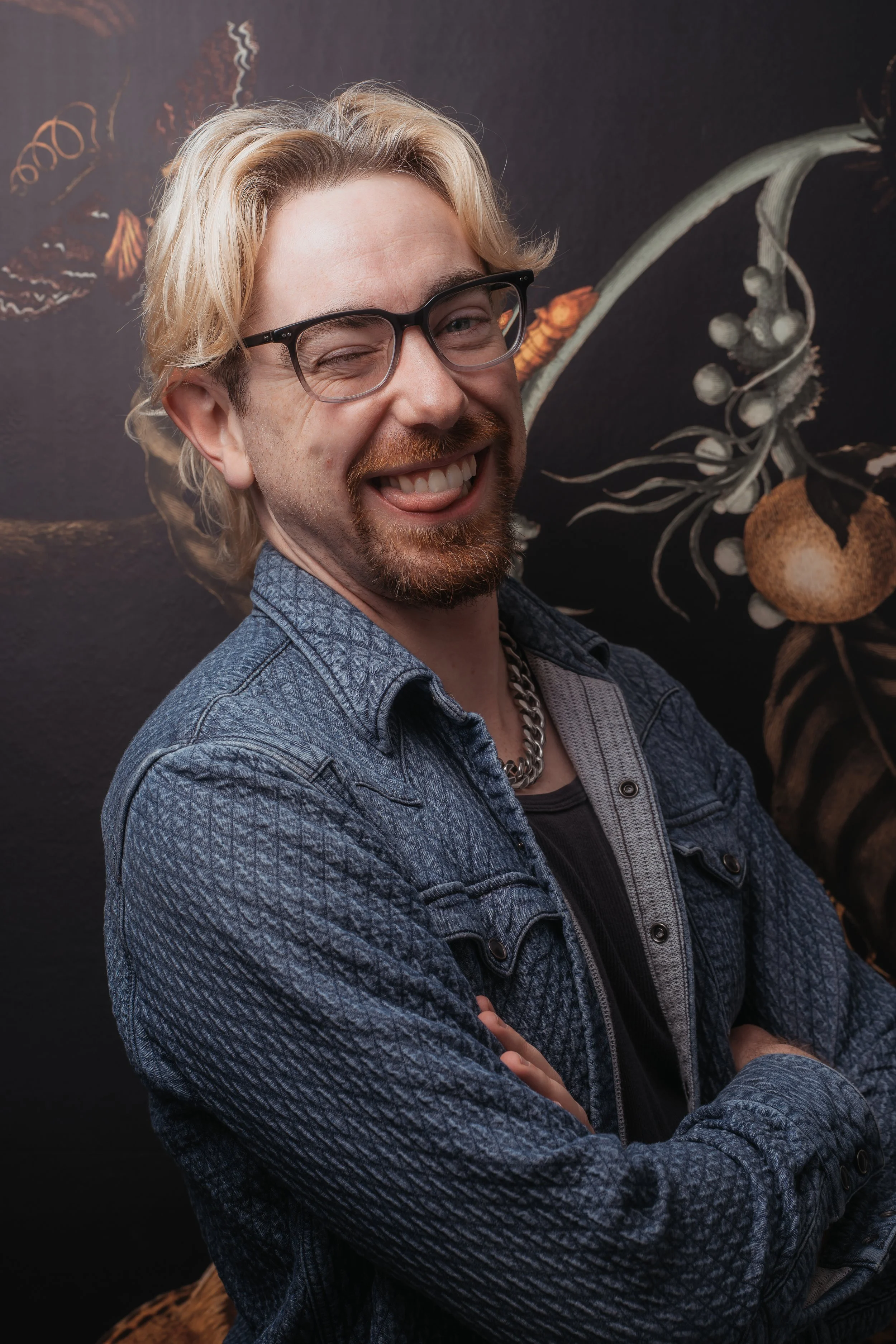 Young man with a plaid shirt with glasses on. A kind smile and an excellent barber 