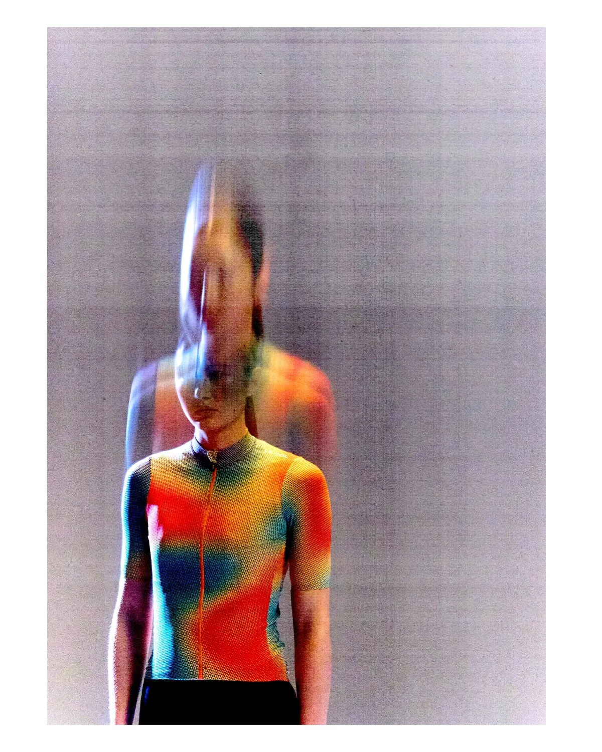 A digital art portrait of a woman wearing a colorful, rainbow-patterned sports shirt, with a blurred, glitch-effect overlay and a neutral gray background.