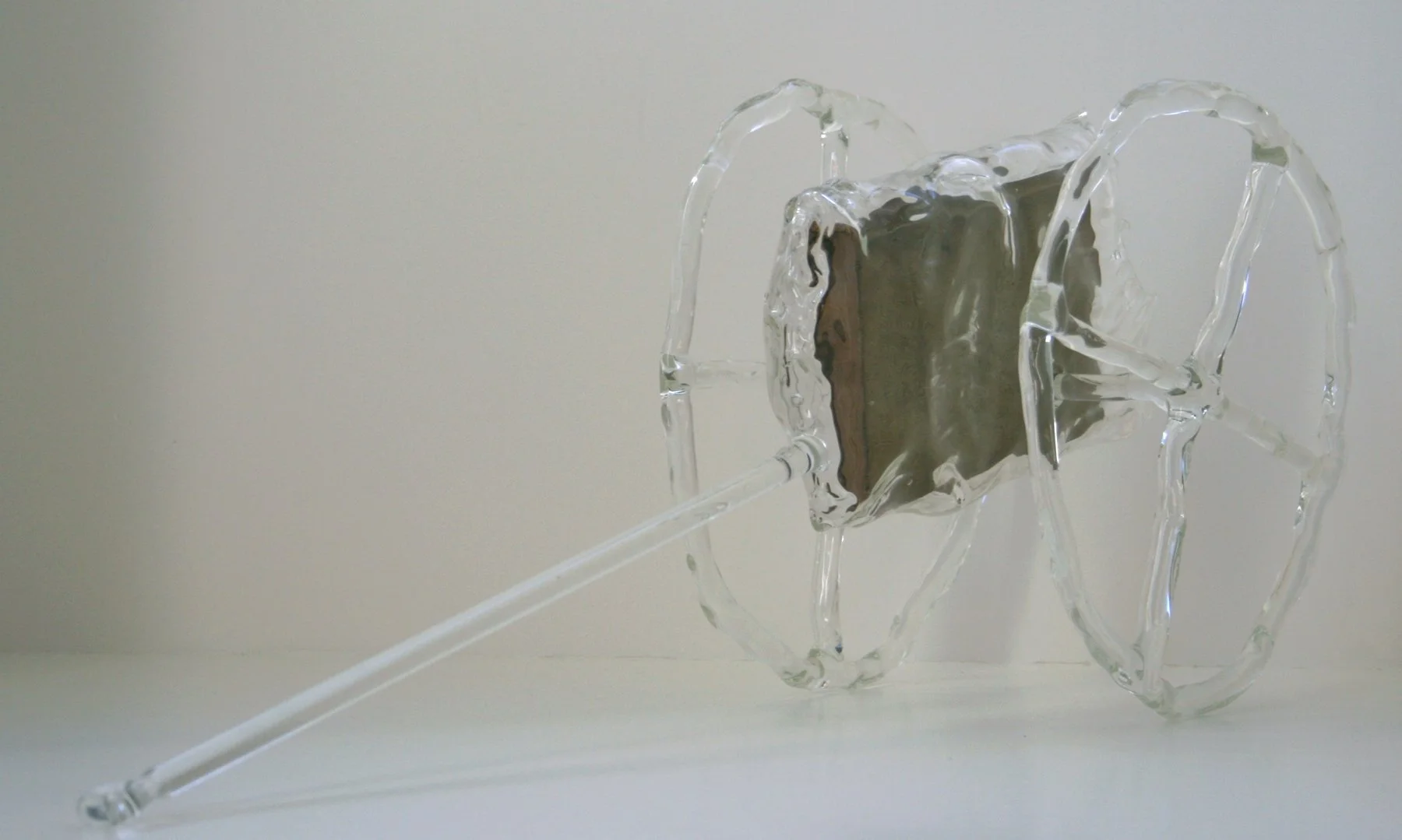 Glass art sculpture resembling a scuba tank with a long tube extending from it, made of clear glass with intricate details.