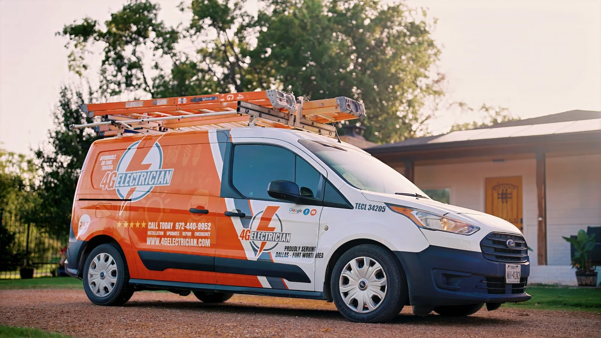 Orange and white service van labeled 4G ELECTRICIAN parked in front of a house with a ladder on top.