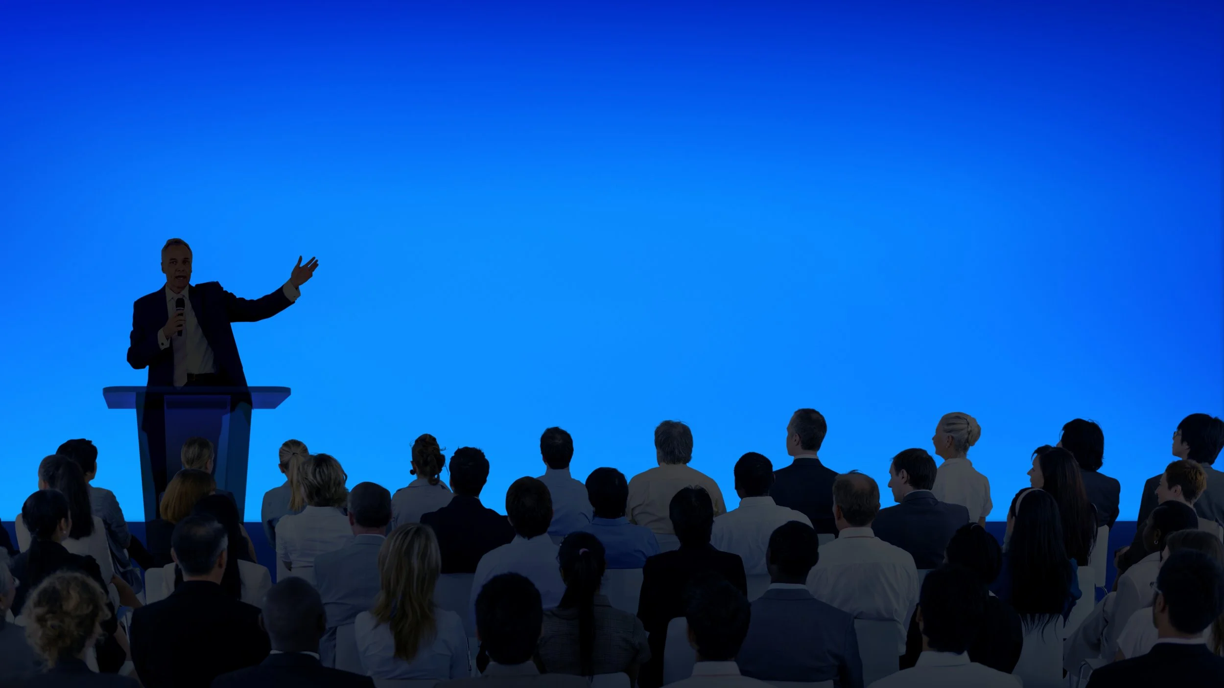 corporate-businessman-giving-presentation-large-audience.jpg