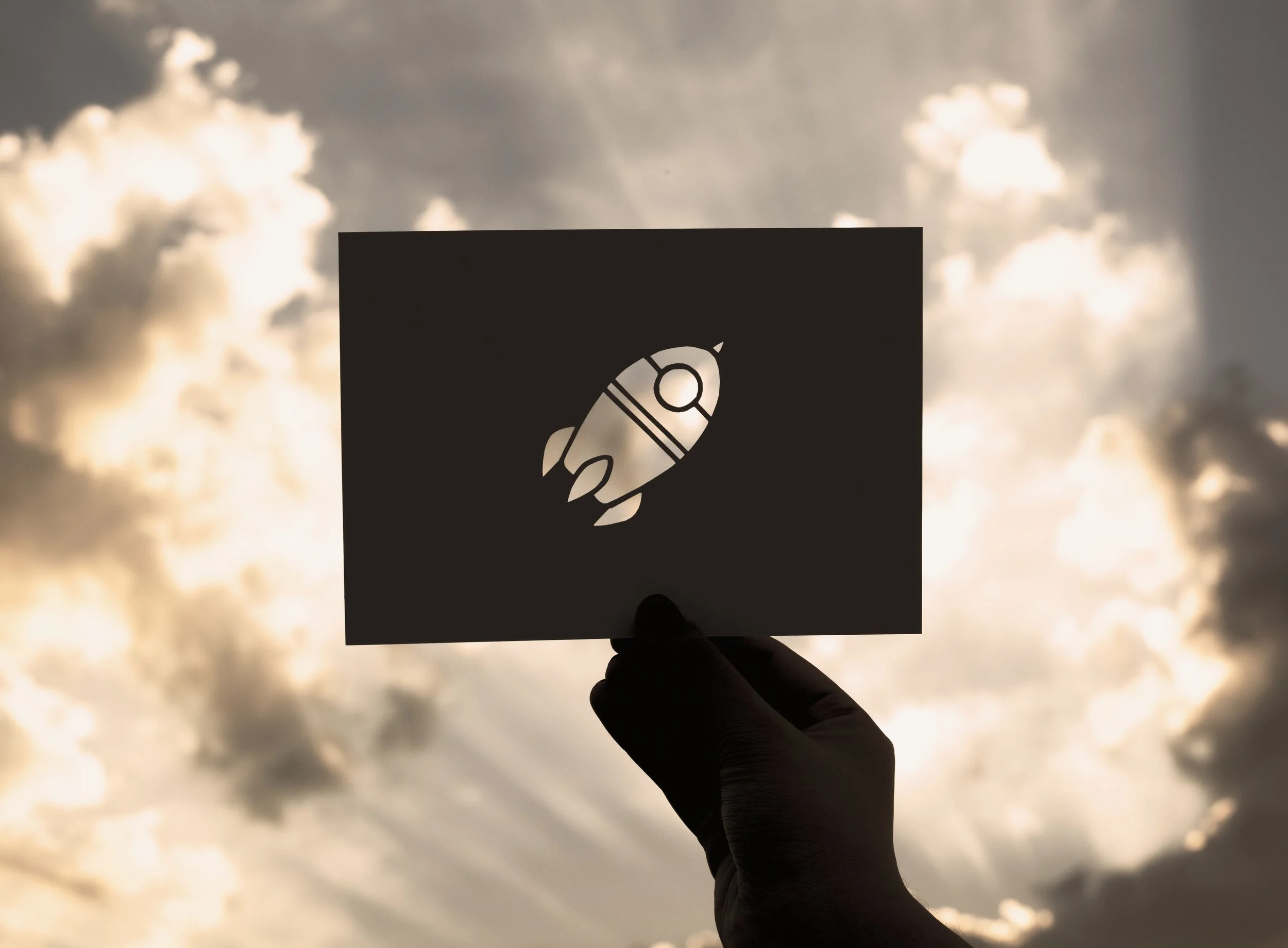 hand-hold-space-rocket-paper-carving-with-sky-background.jpg