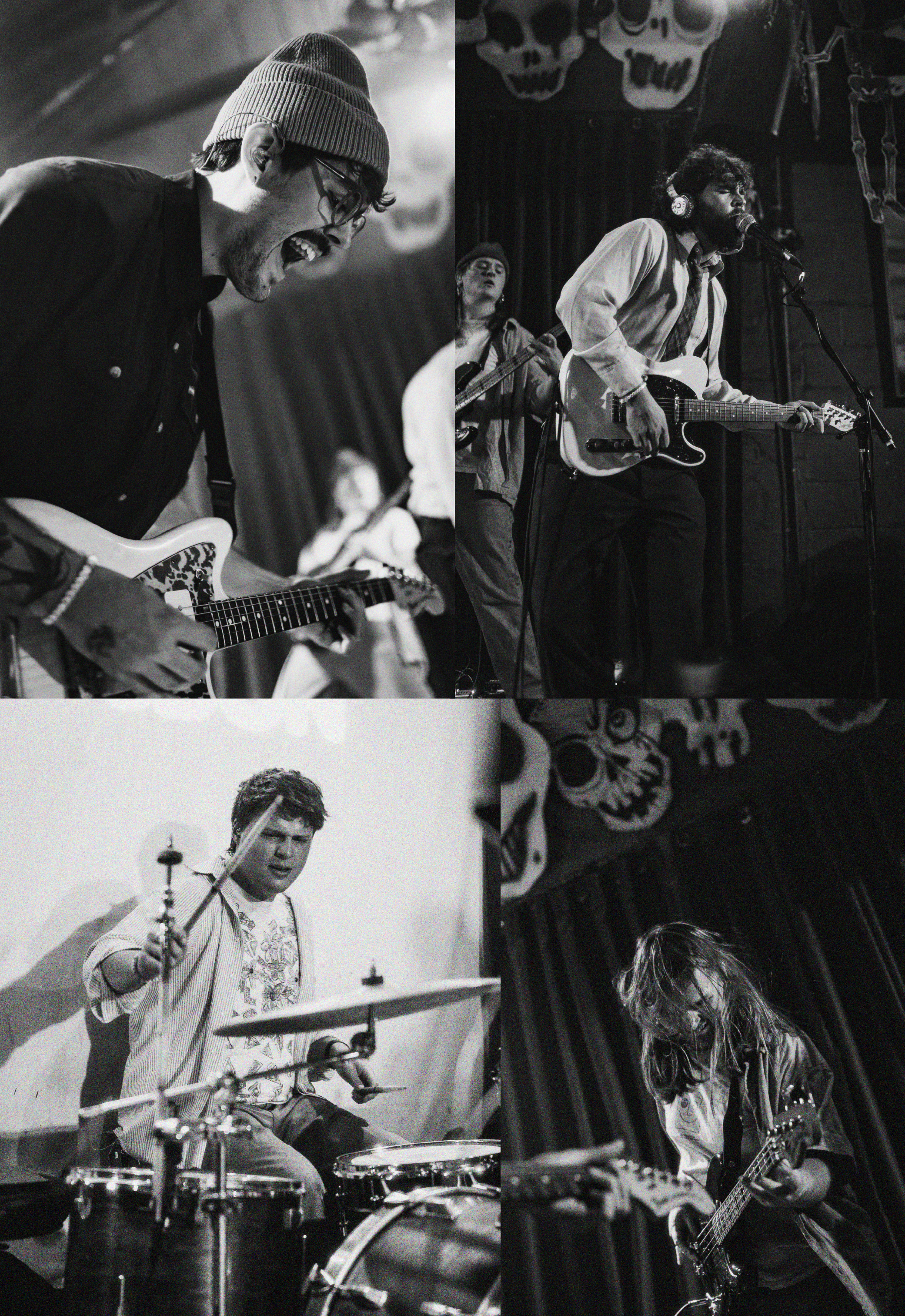 Black and white photo of a band performing on stage, featuring a singer with a guitar, a drummer, and a musician with a bass guitar, in front of a backdrop with skulls and weapons.
