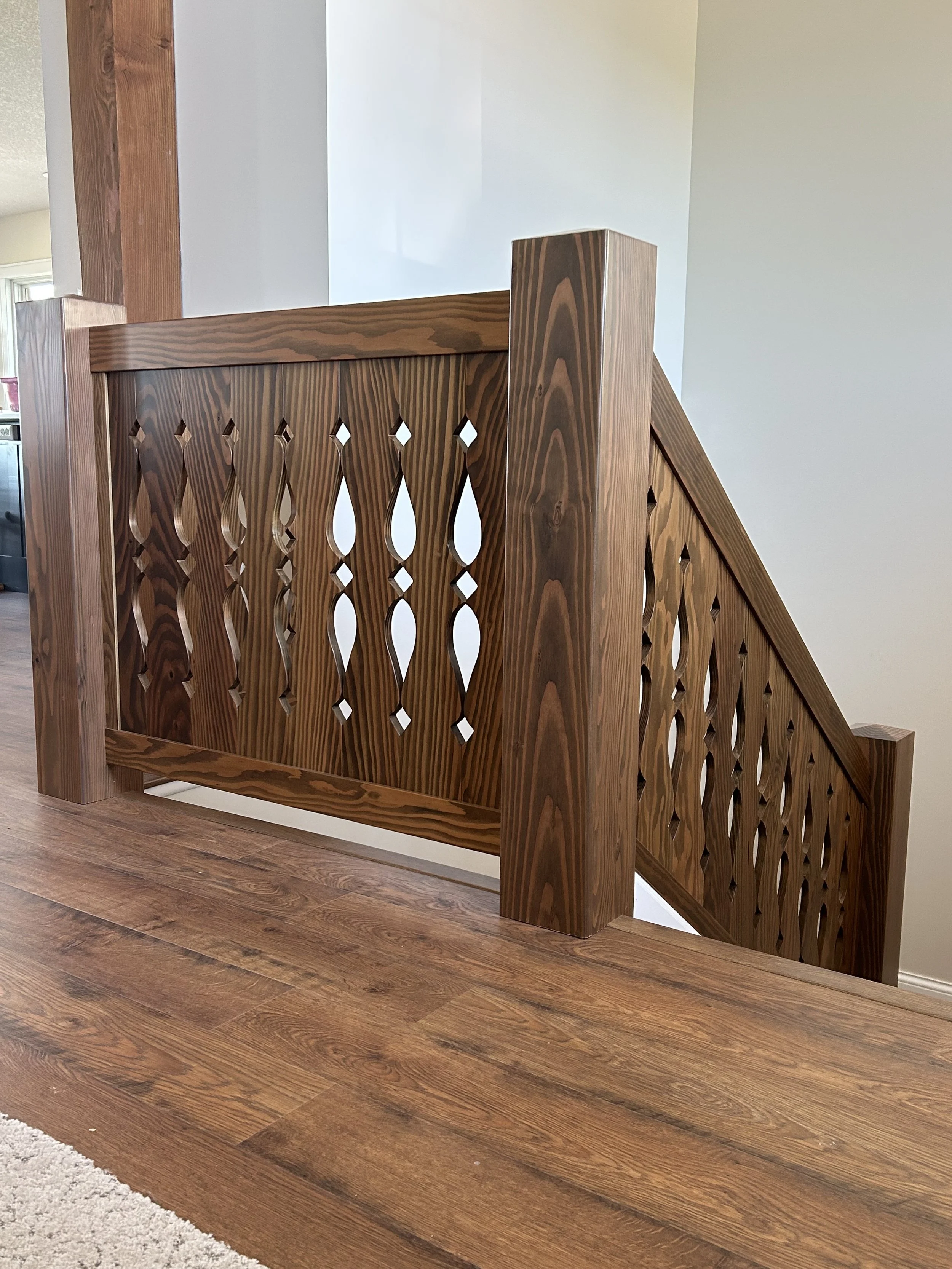 Close-up detail of custom stair railing showing carved Norwegian-inspired geometric and flowing motifs.
