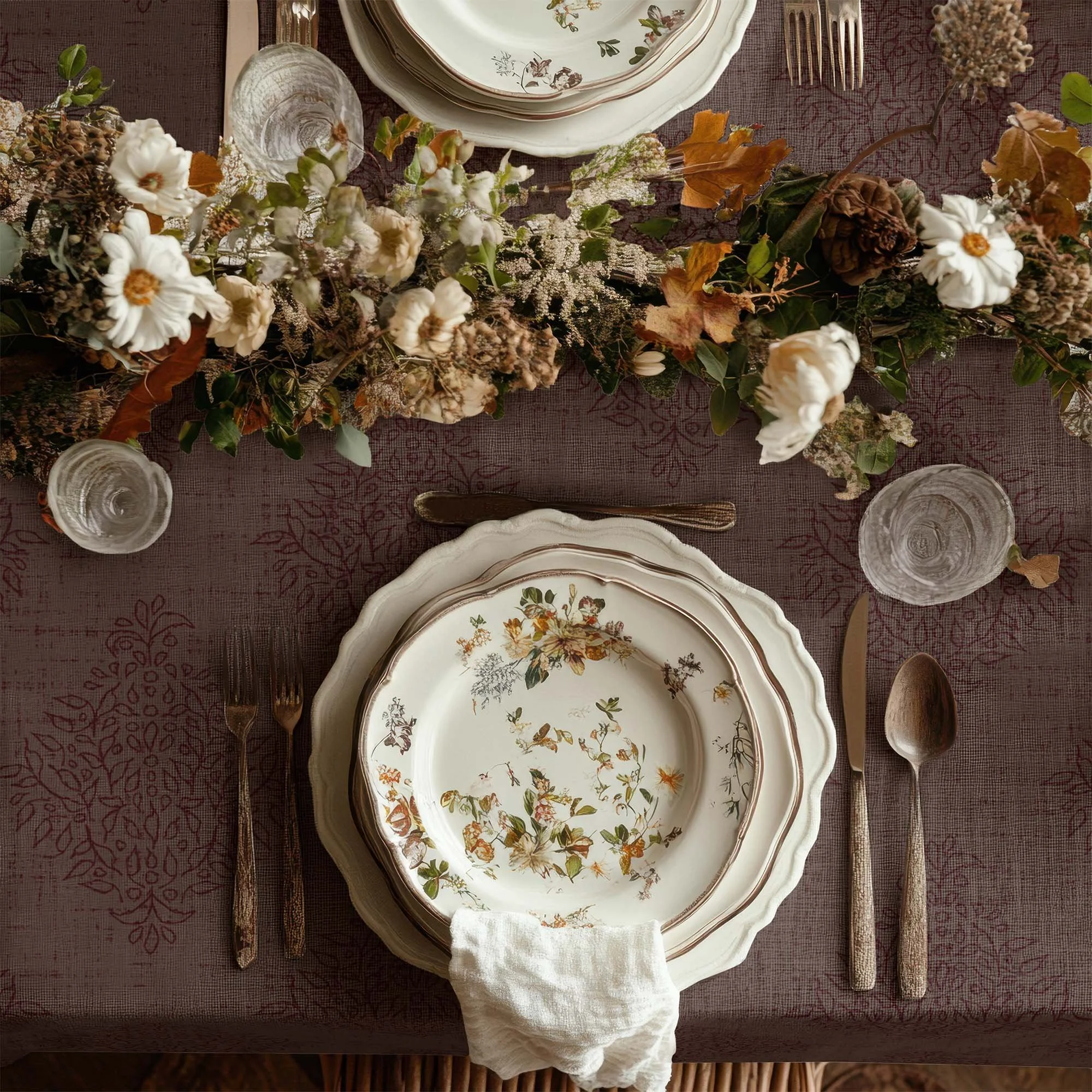Oxblood cordovan Grove Vine damask tablecloth beneath vintage floral dishes and an abundant autumn centerpiece of flowers, leaves and greenery.