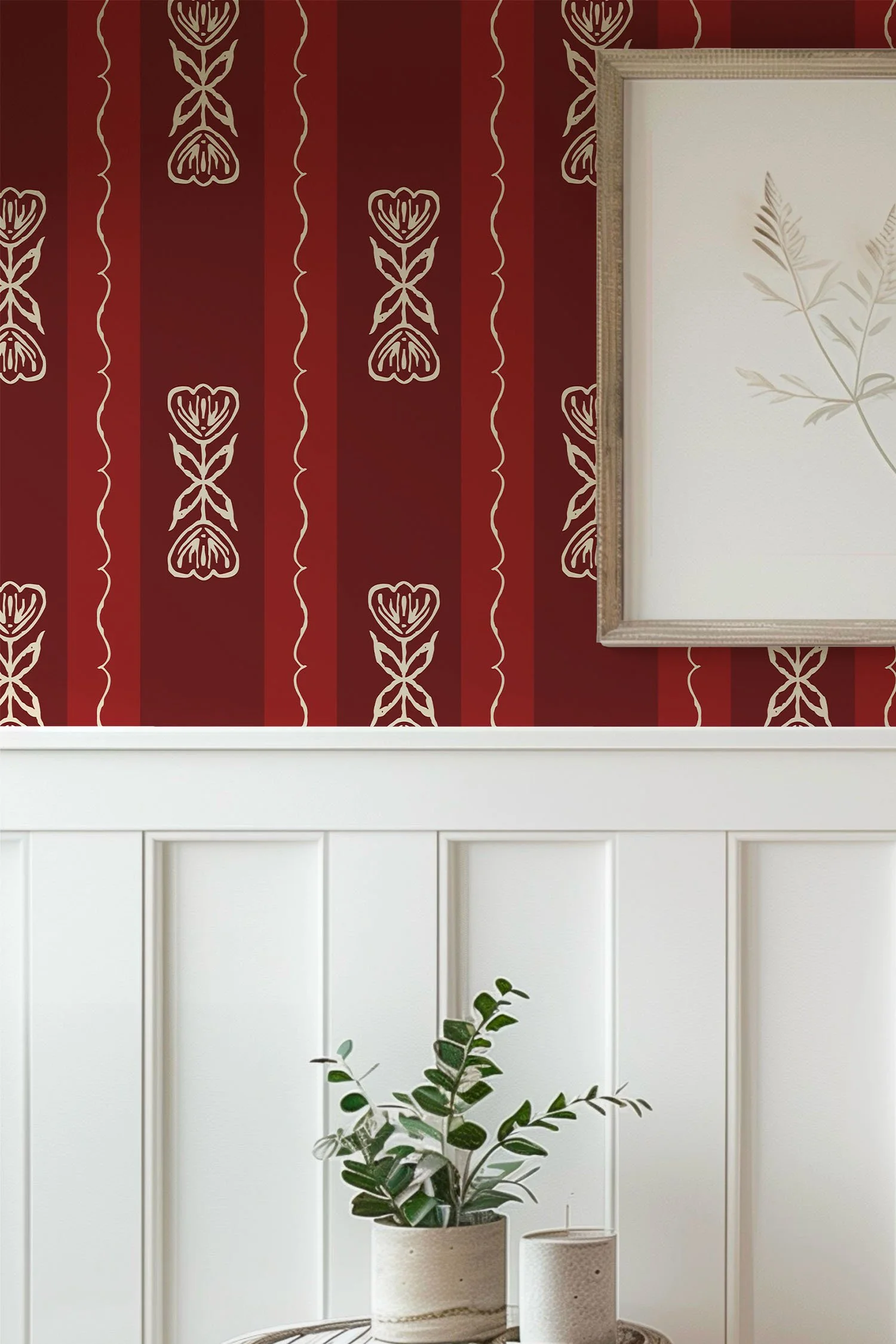 Red and ivory Scandi Tulip floral stripe wallpaper above white paneled wainscoting, with framed botanical artwork.
