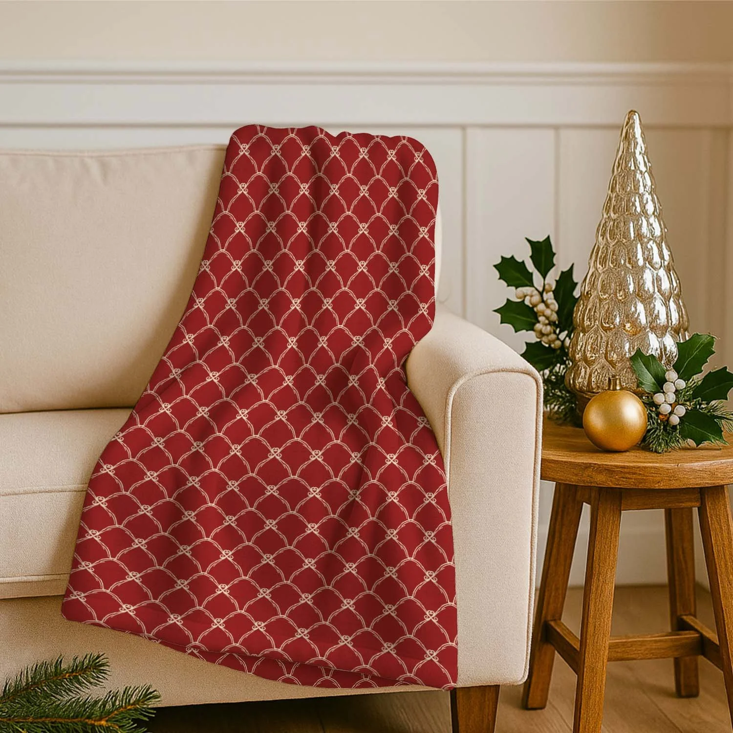 Red Scandi Tulip scalloped geometric throw blanket draped over a cream sofa beside Christmas greenery and a gold ornament.
