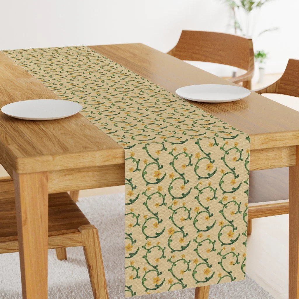 Wood table styled with floral vine table runner featuring green vines and yellow flowers on beige