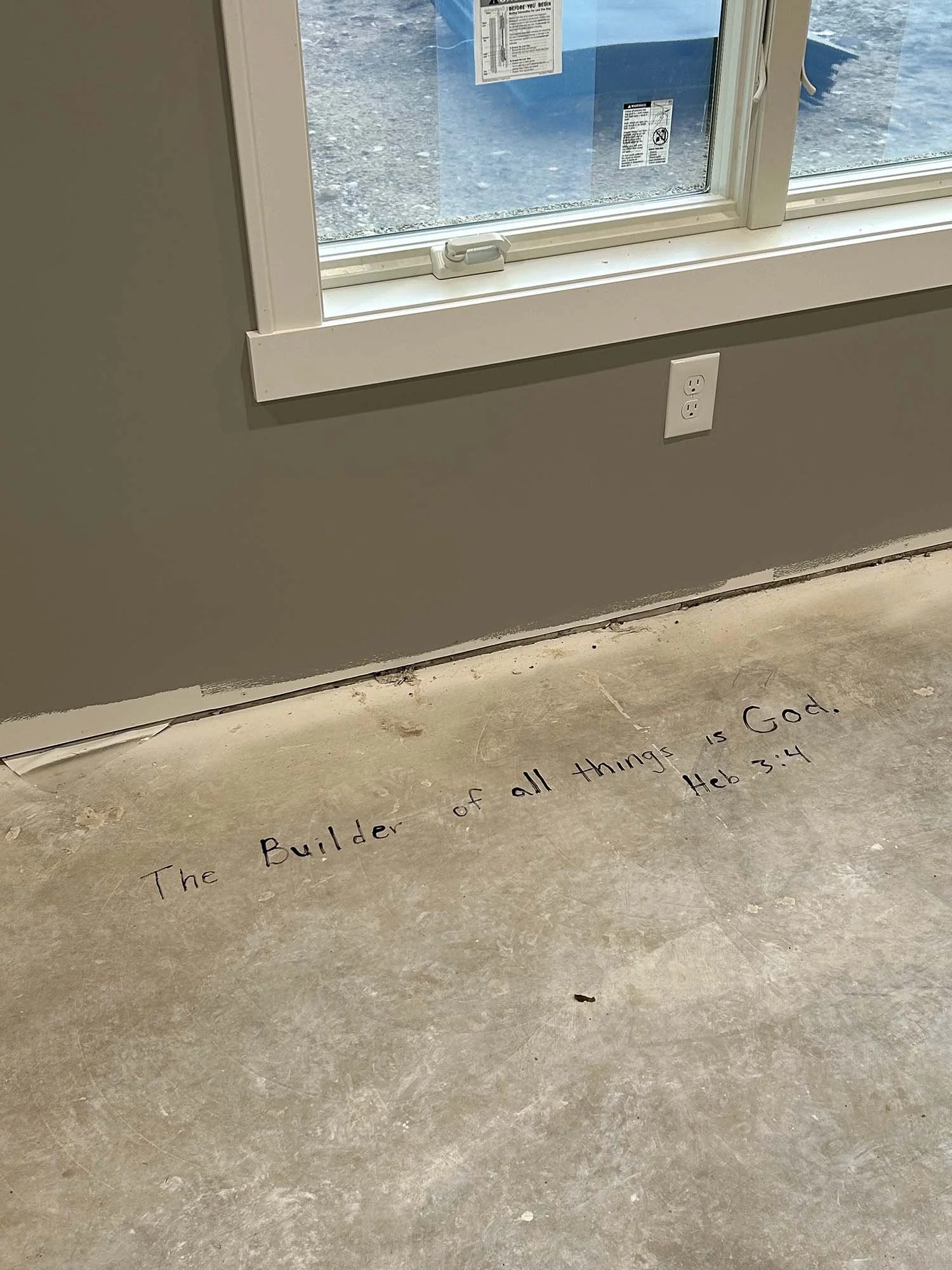 Hebrews 3:4, “The builder of all things is God,” handwritten on the unfinished floor during construction of our home.