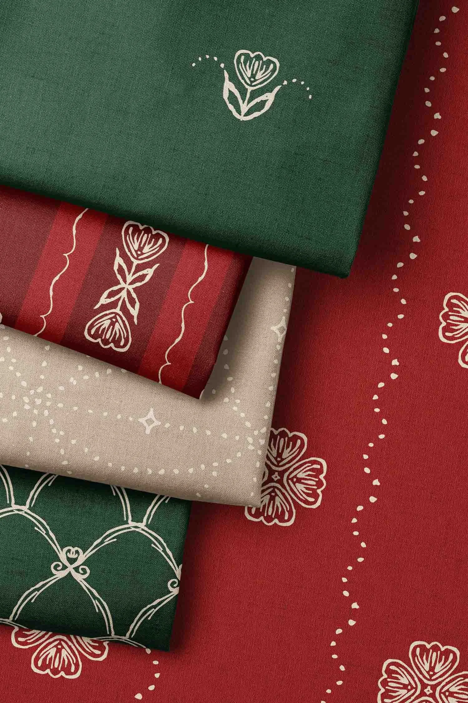 Arrangement of coordinating Scandi Tulip fabrics in Christmas red, forest green, and warm tan, featuring floral and geometric patterns.