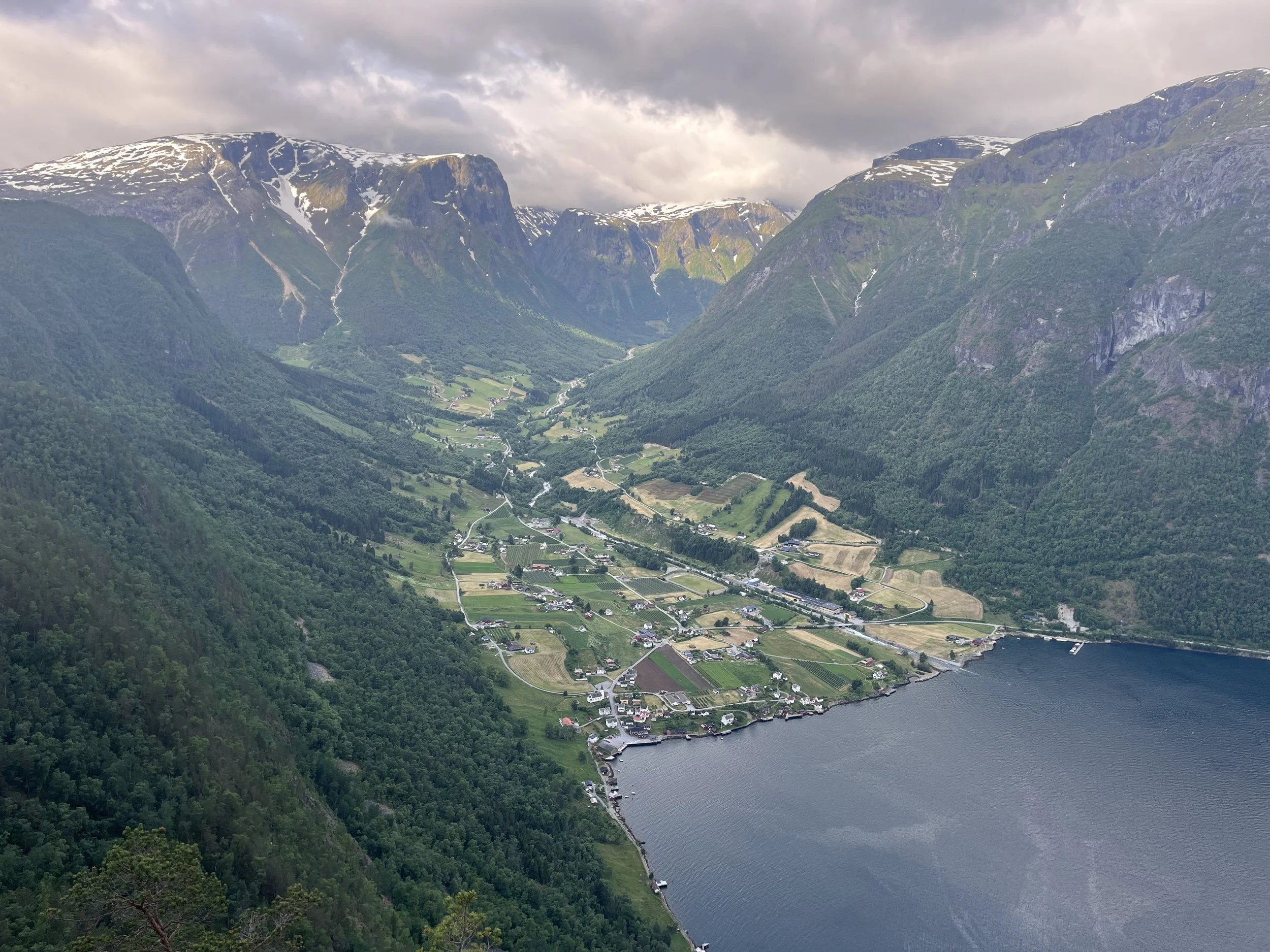 Mountain valley and fjord landscape in Fresvik, Norway, surrounded by steep mountains and farmland.