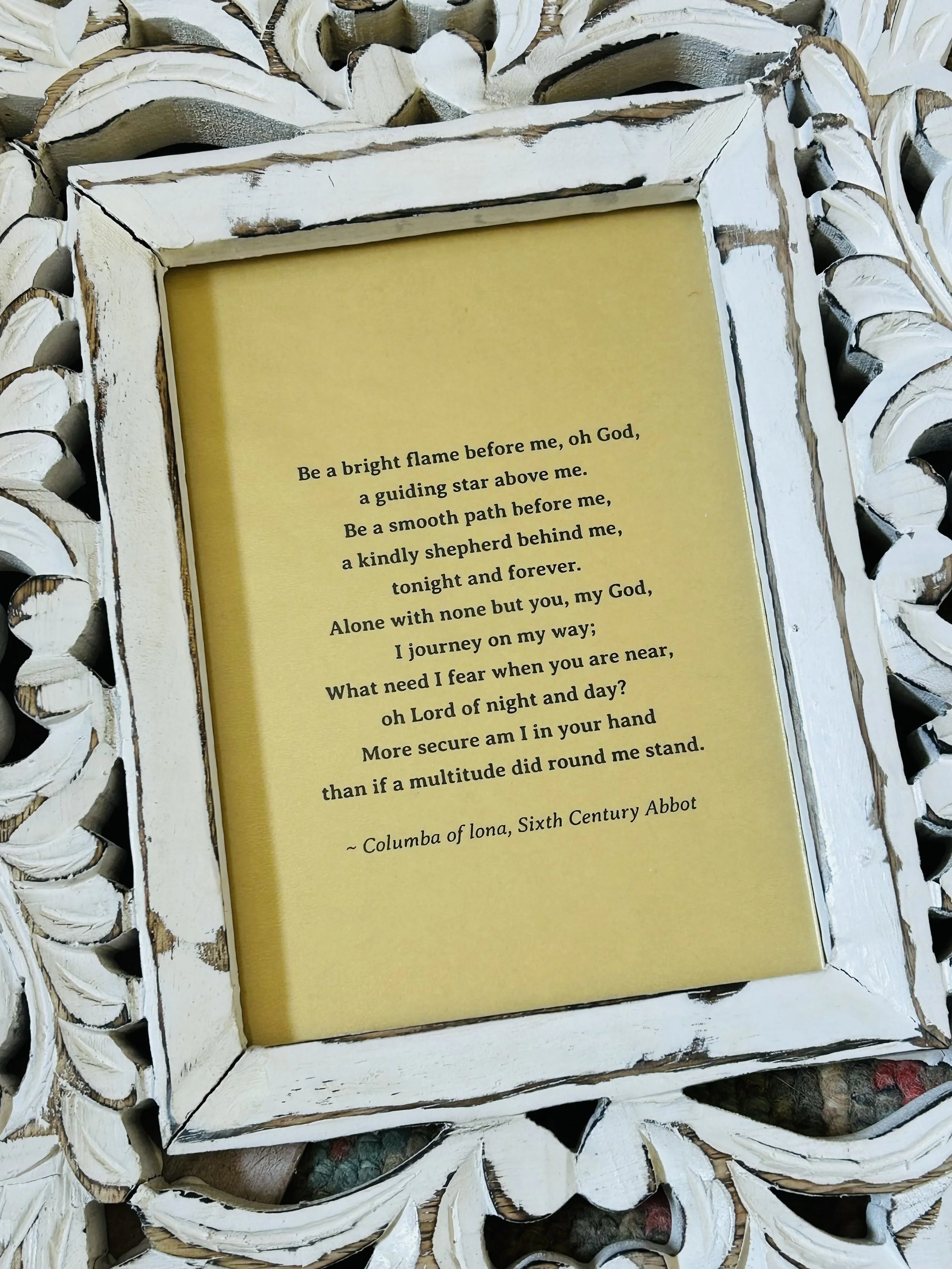 Framed prayer attributed to St. Columba displayed in a carved white wooden frame, with words about God’s guidance, protection, and presence.
