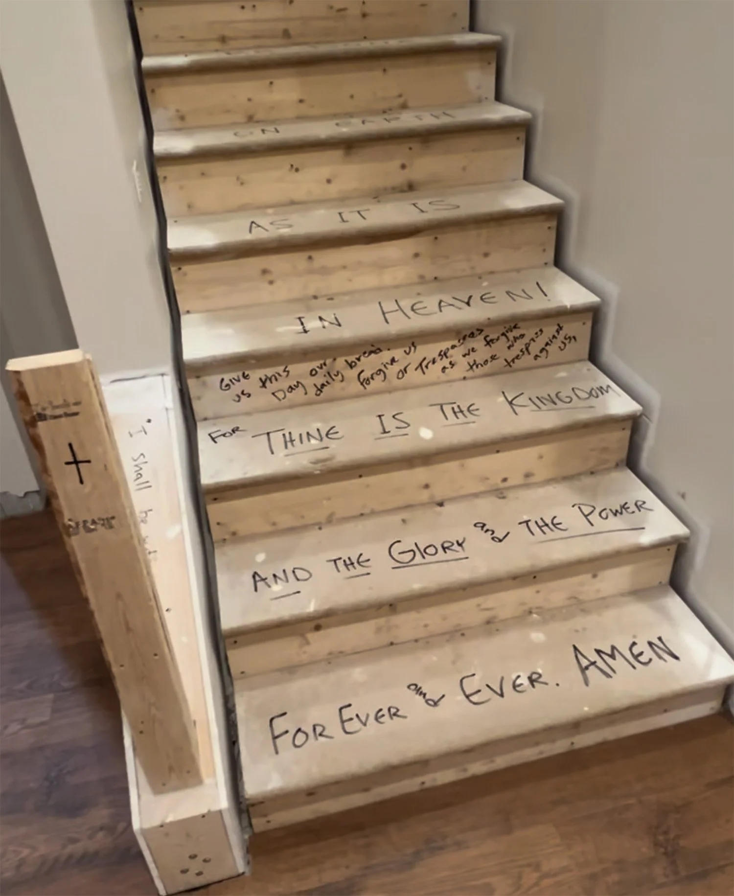 Bible verses handwritten on unfinished wooden stairs during construction of a family home.