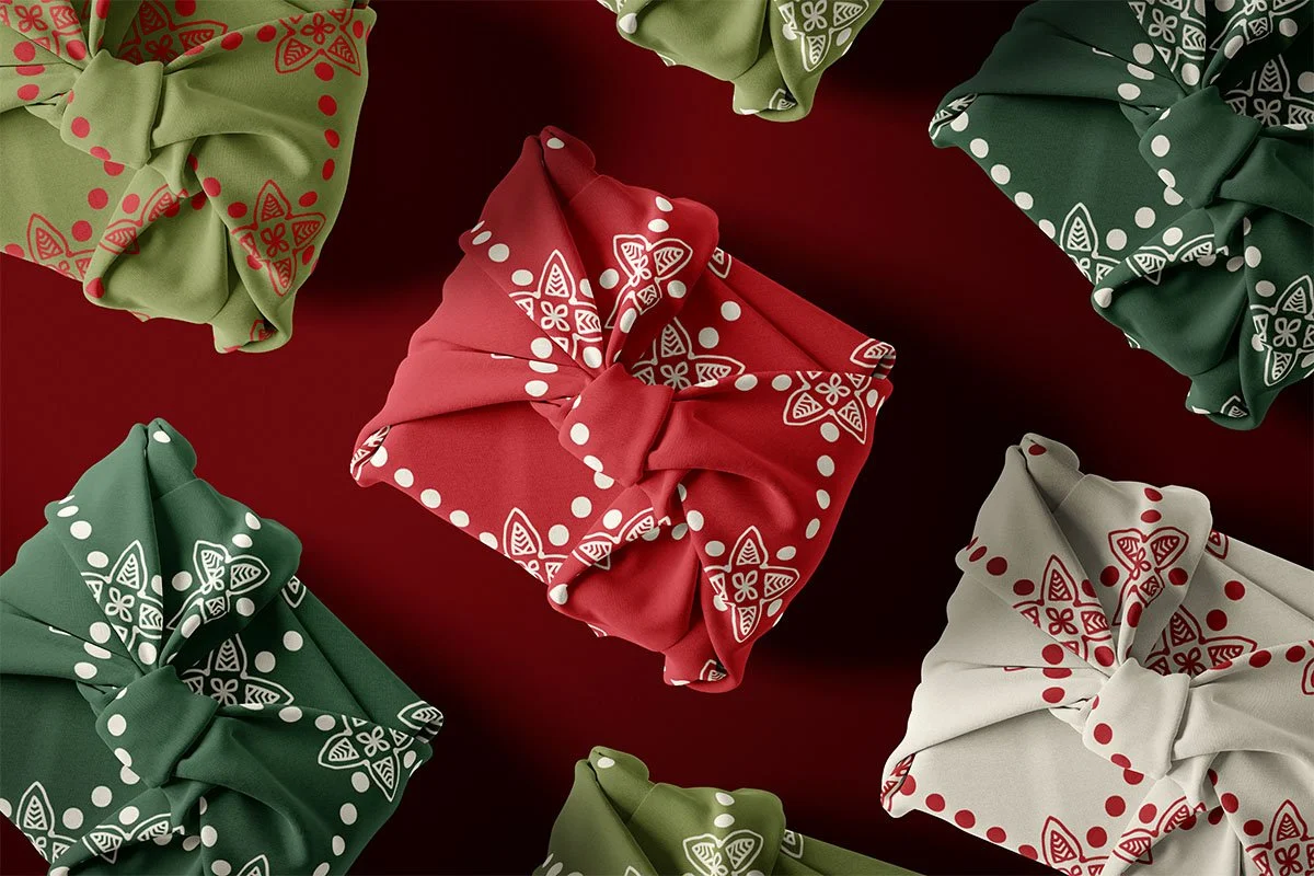 Christmas gifts wrapped in coordinating red, green, ivory and light green patterned fabrics.