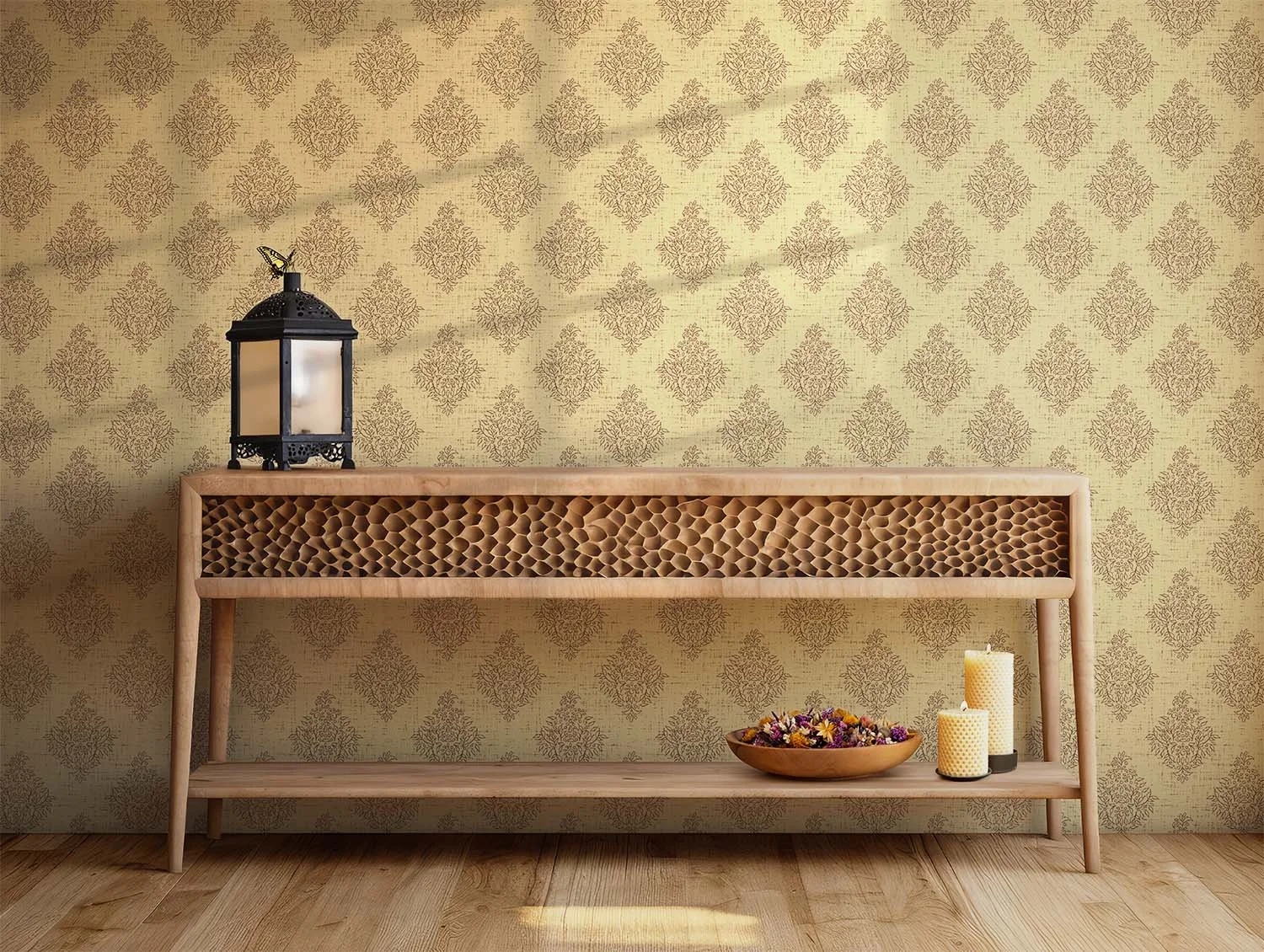 Tavern Buttermilk Quiet Garden Damask wallpaper behind a carved wood console table styled with a lantern, candles and a bowl of dried flowers.