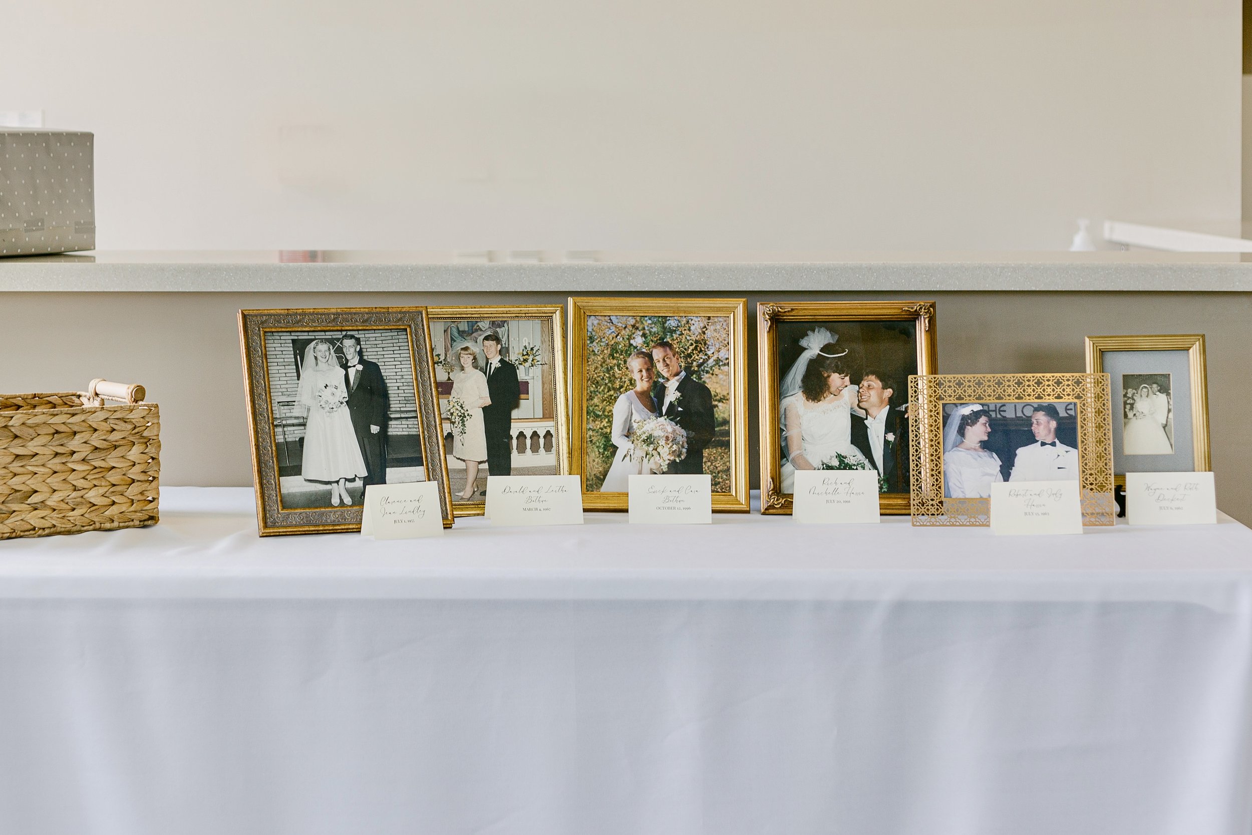 Framed wedding photographs from multiple generations displayed at the church entrance to honor lasting family marriages.
